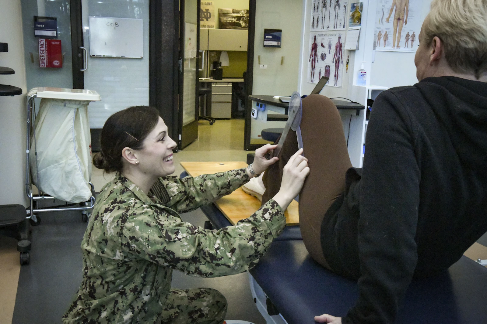 A physiotherapist measuring range of motion at a patient knee inside the GATI clinic