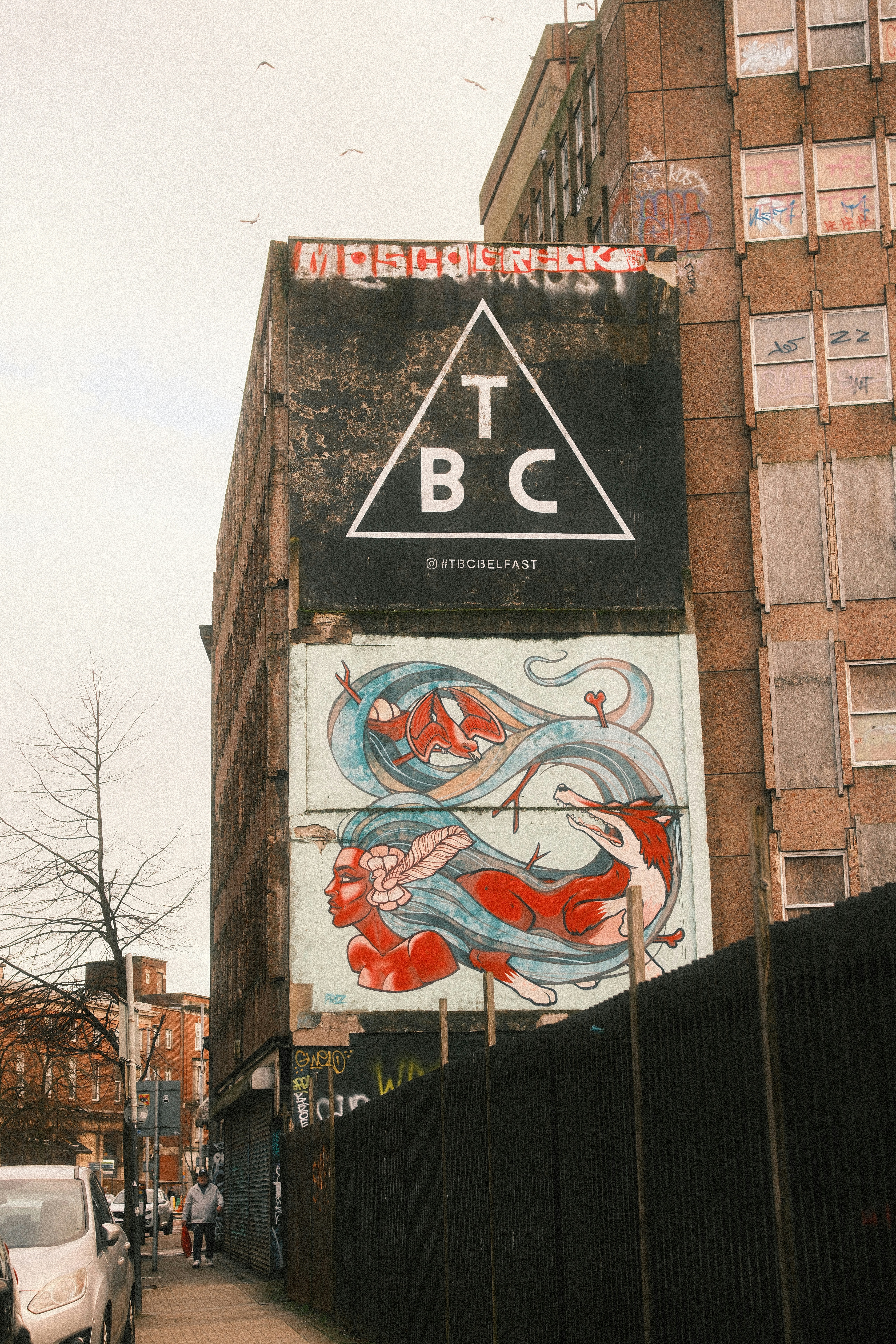 Graffiti art on a building with a triangle logo.