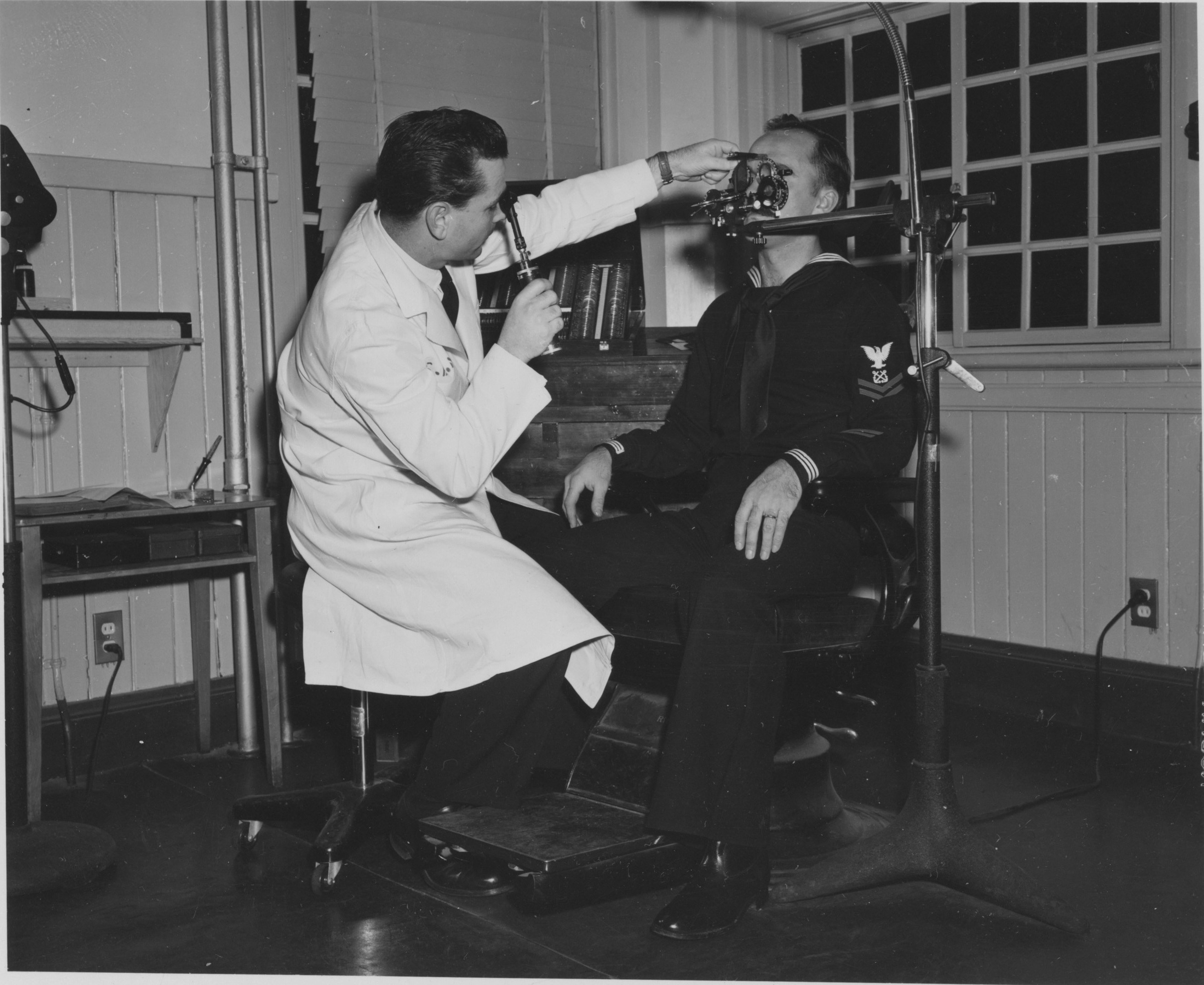 Doctor examines patient's eye with equipment.