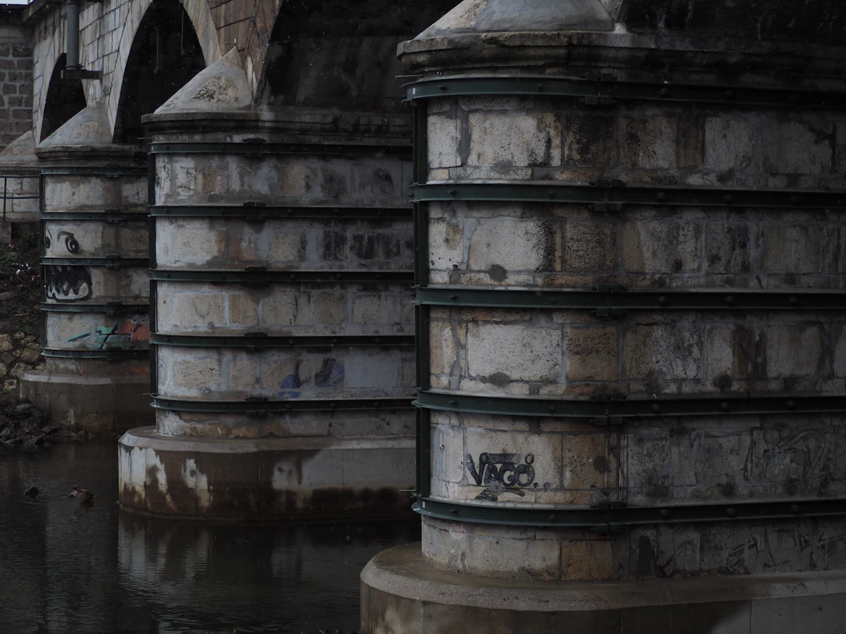 Stone bridge piers meeting the water — the toe-of-structure zone where Texas Tuff Rock Bags armor against contraction scour and undermining