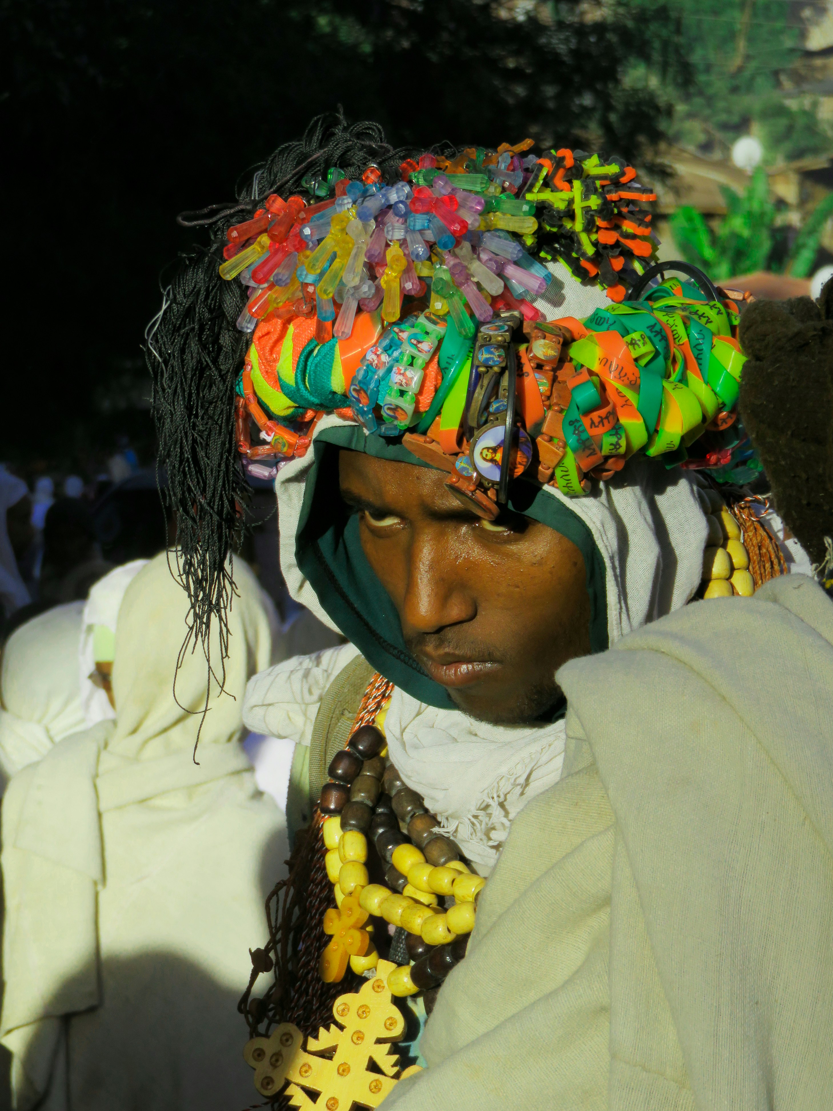 Man wearing a colorful headdress and beaded necklaces.