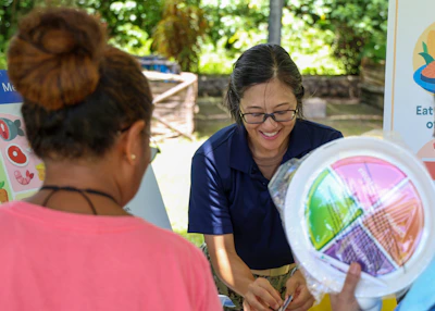 A woman shows a colorful plate to another person.