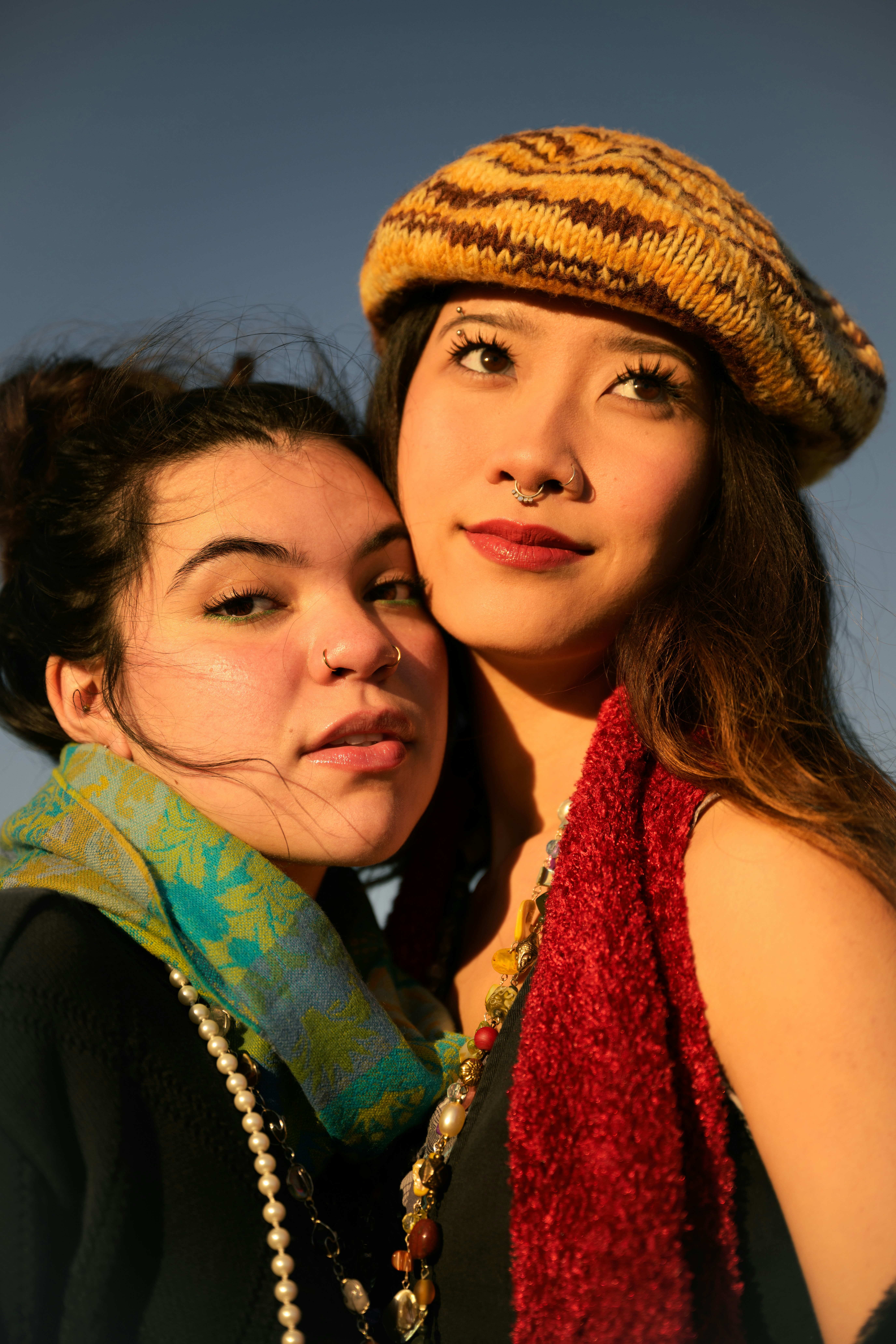 Two young women posing together outdoors.