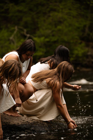 Women in white dresses by a river