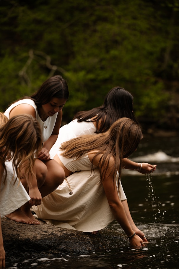 Women in white dresses by a river