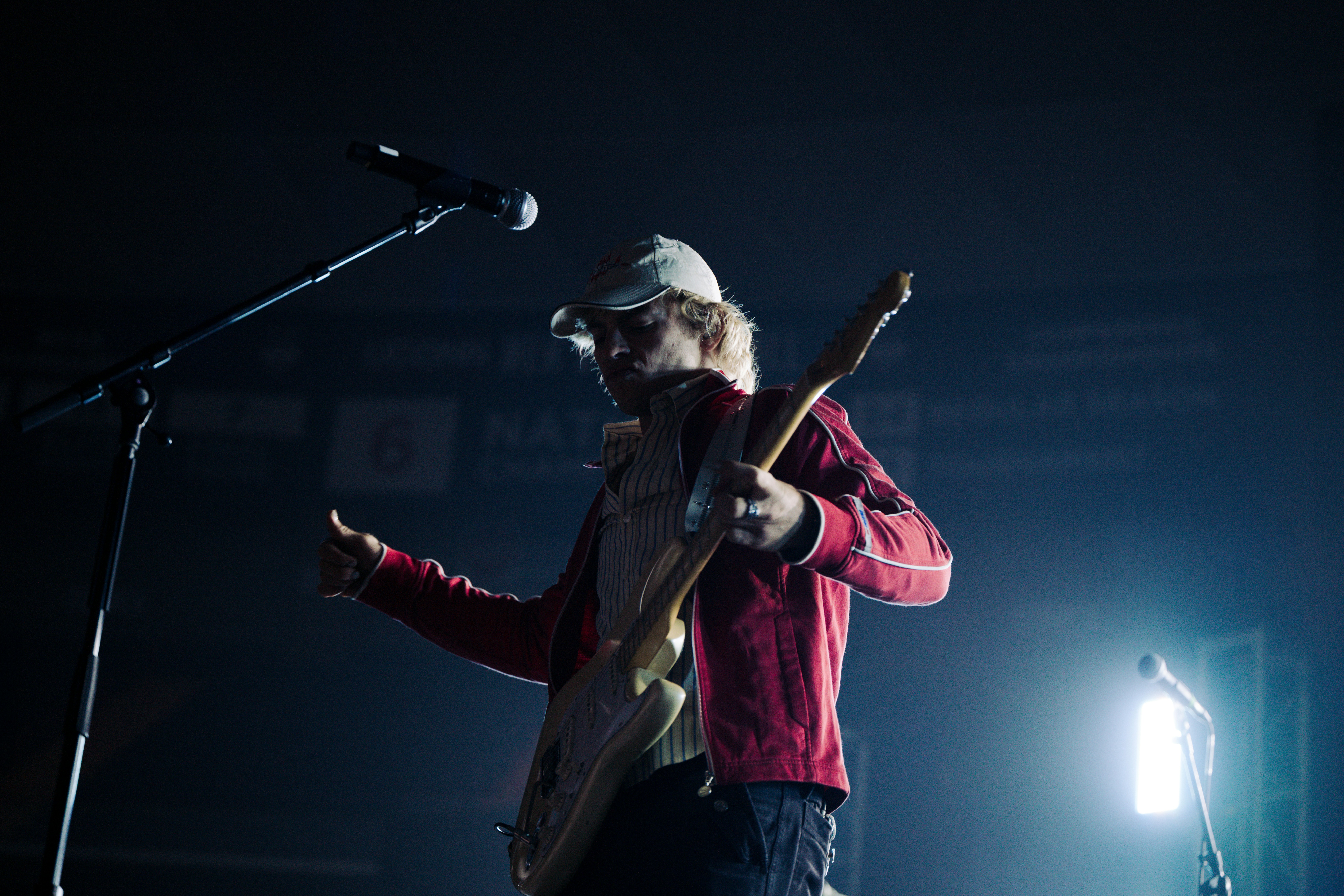 A young man playing guitar on stage