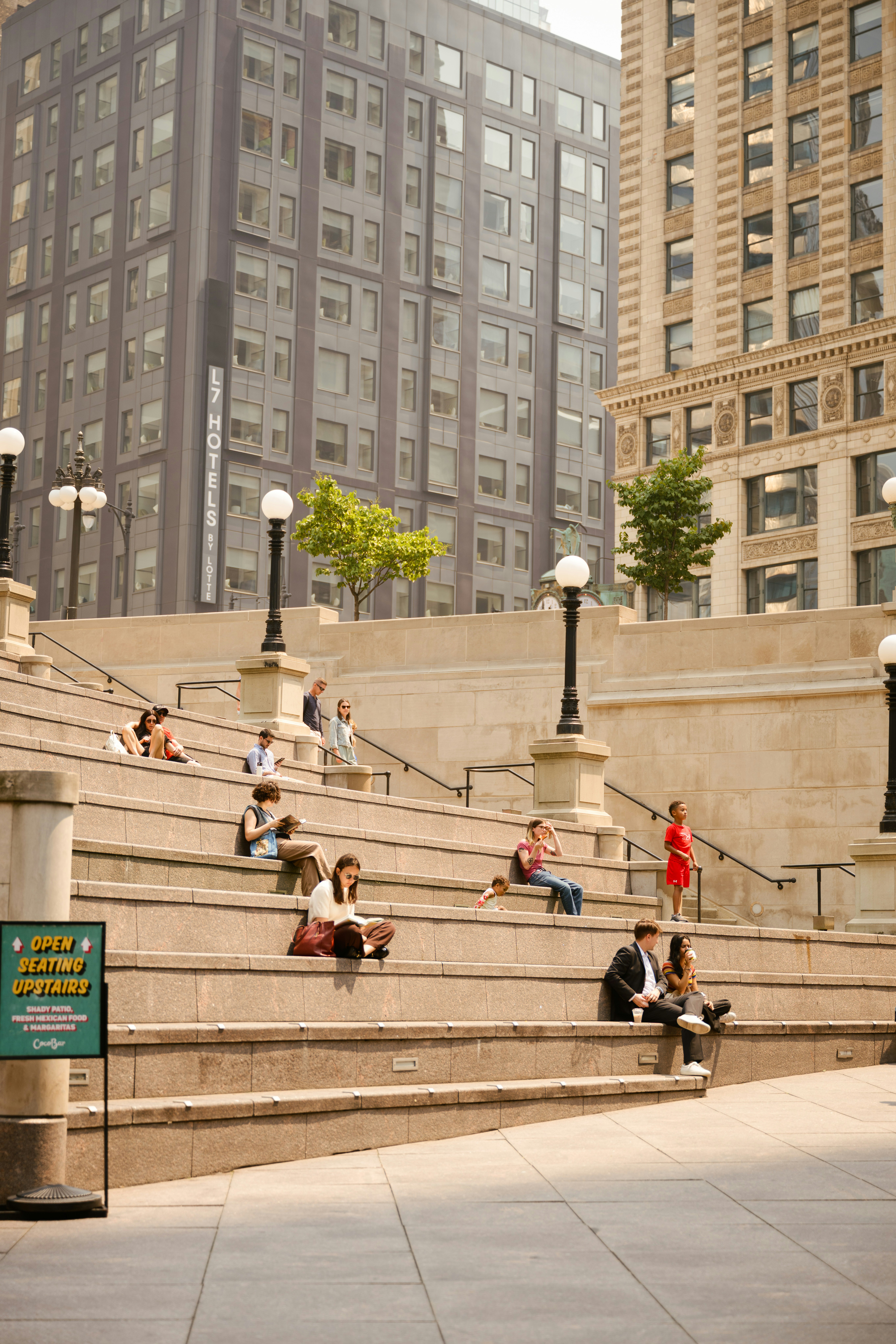 People relaxing on large outdoor stone steps.