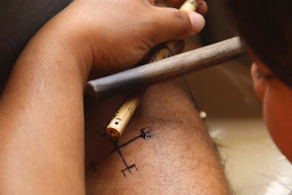 Person applying temporary tattoo with stencil and brush