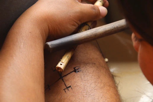 Person applying temporary tattoo with stencil and brush