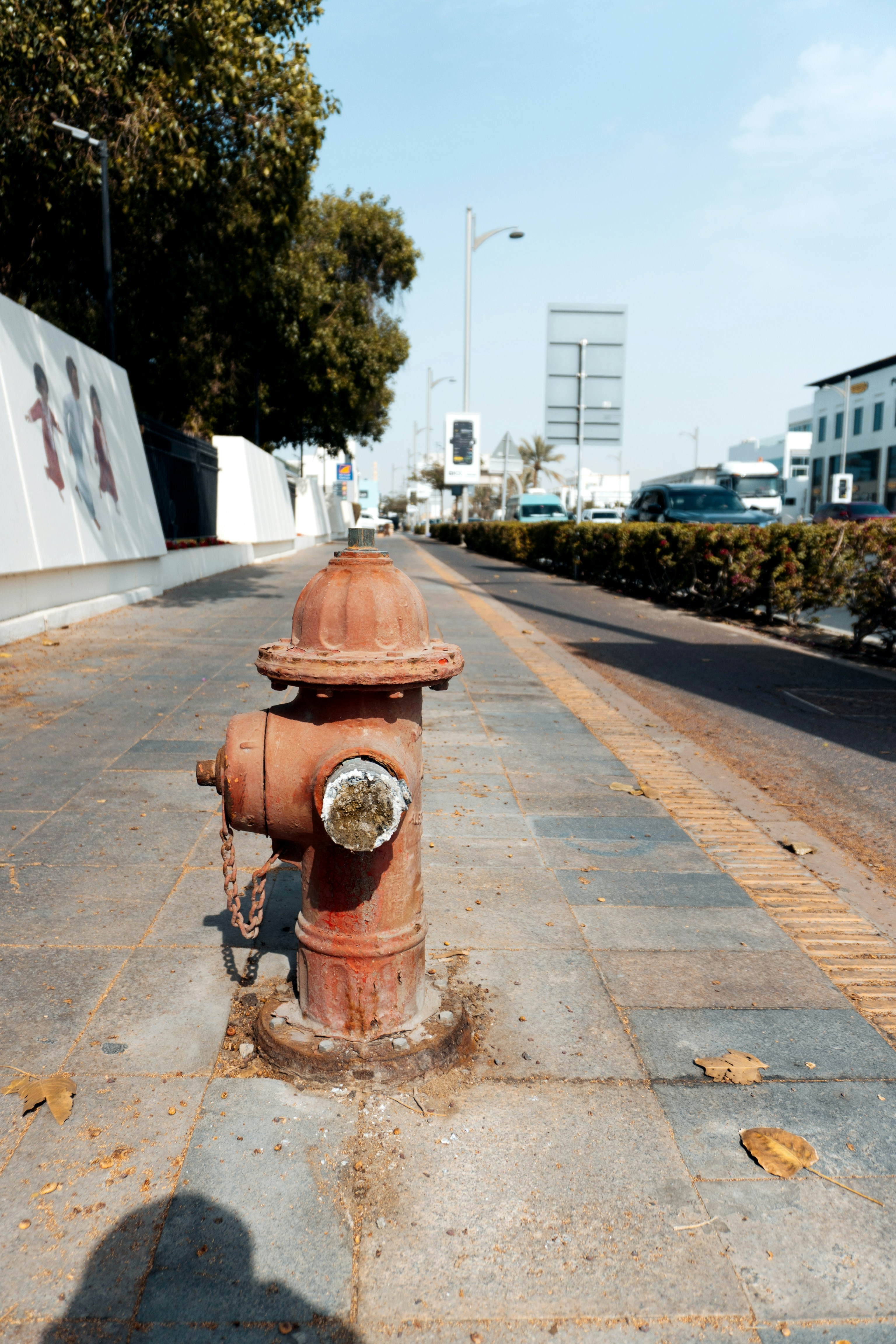 Un idrante rosso arrugginito su un marciapiede.