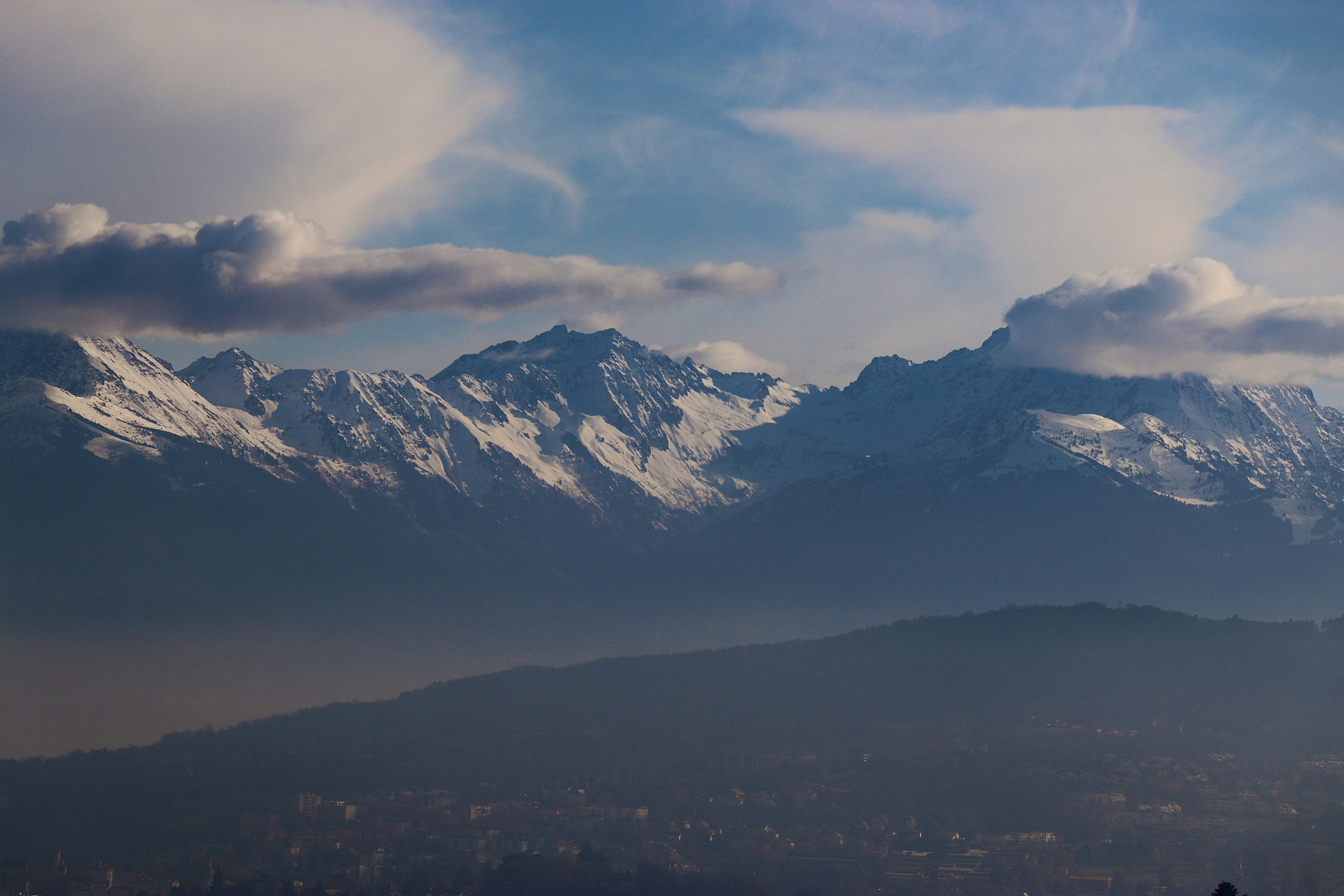 Snow-capped mountains under a cloudy sky