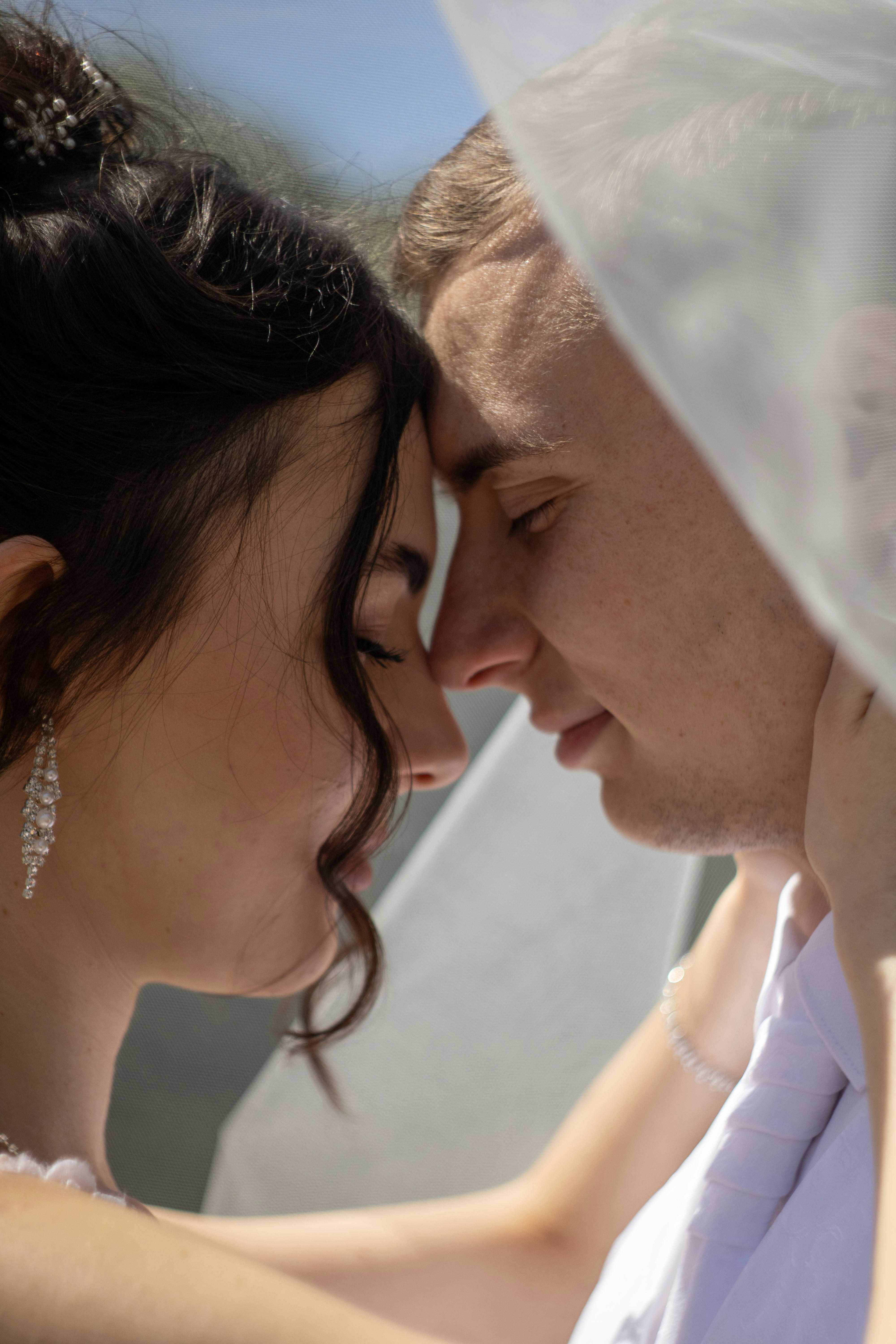 ヴェールの下で目を閉じて抱き合うカップル