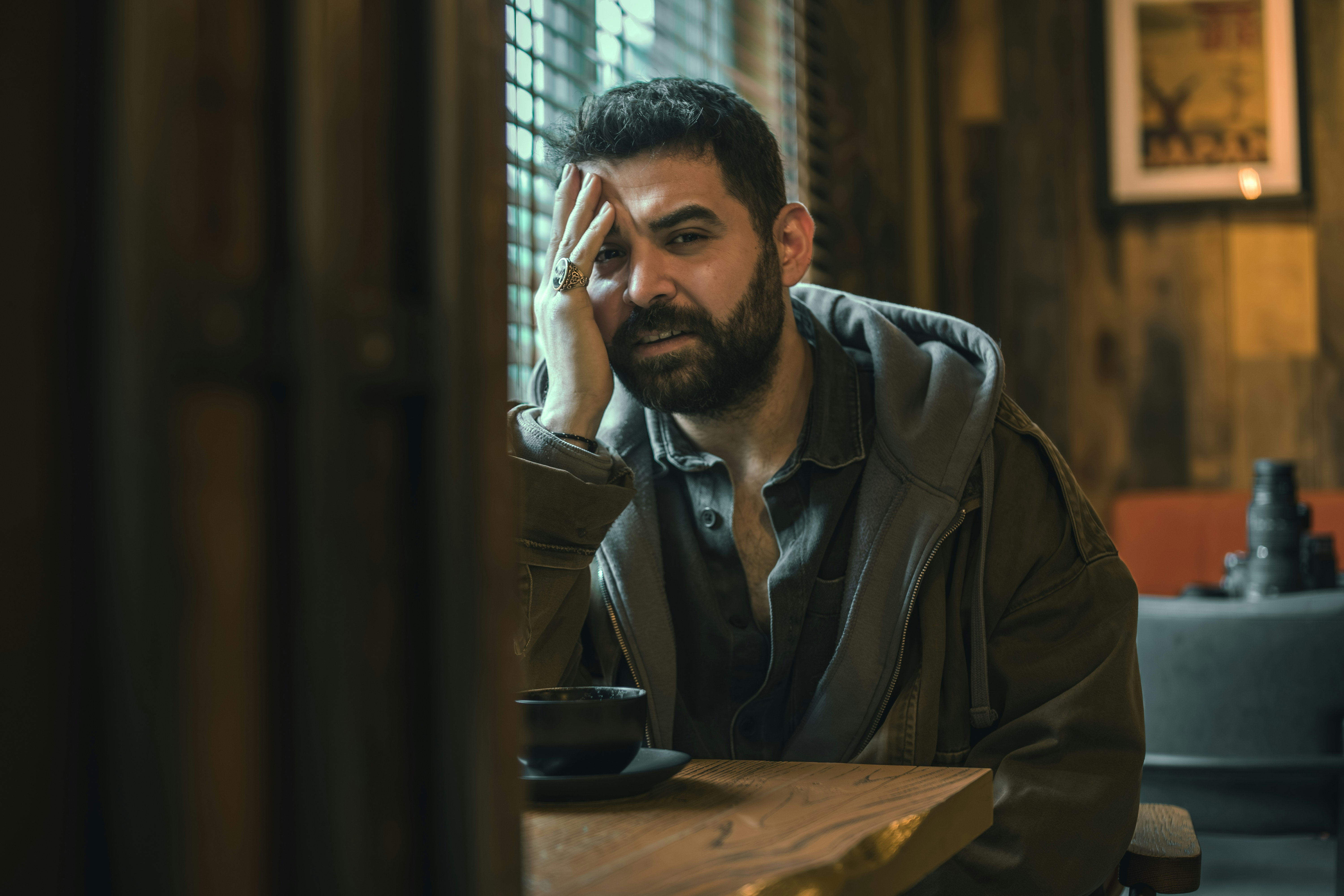 Man sitting at a table with a cup of coffee.