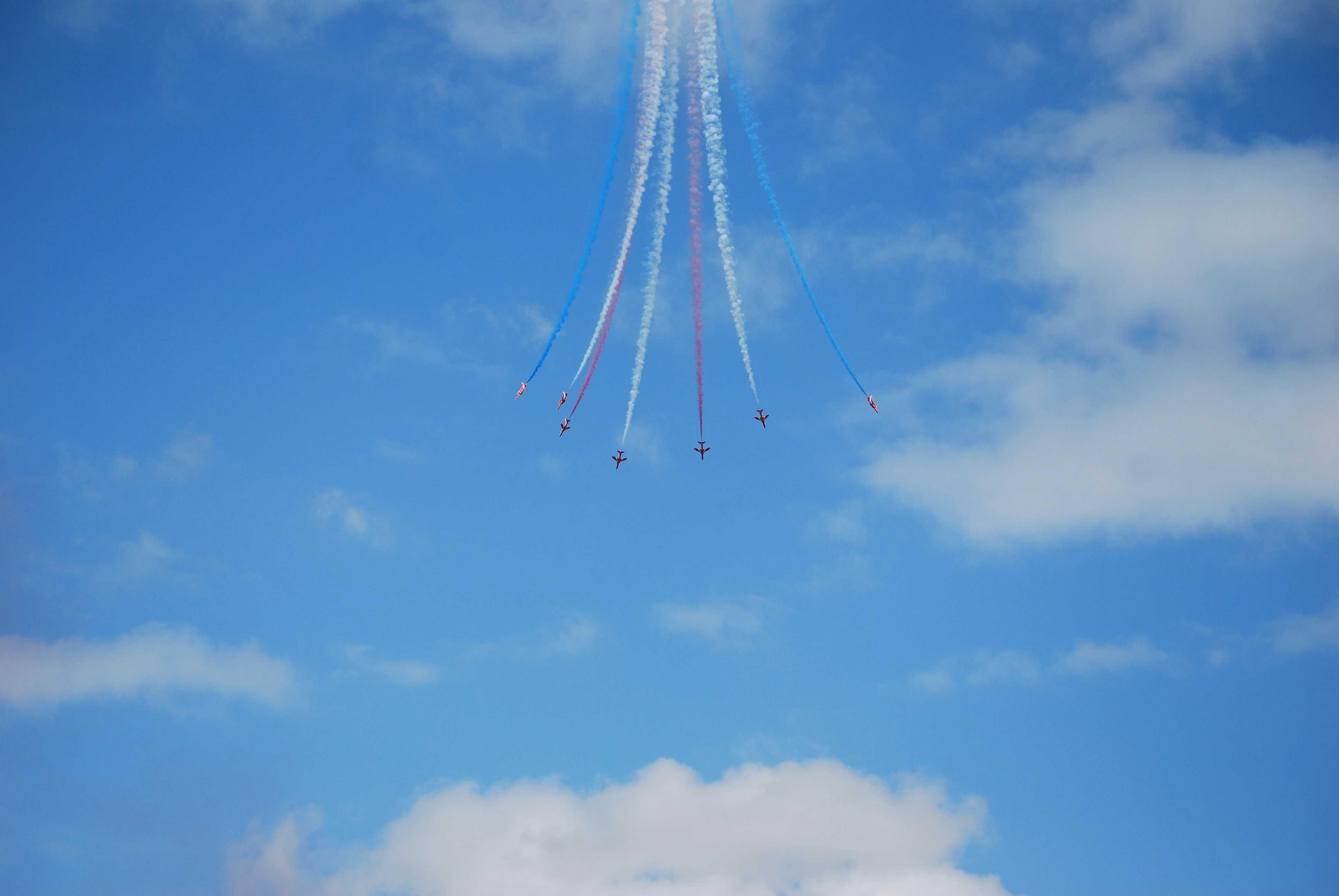 Five jets fly in formation leaving smoke trails.