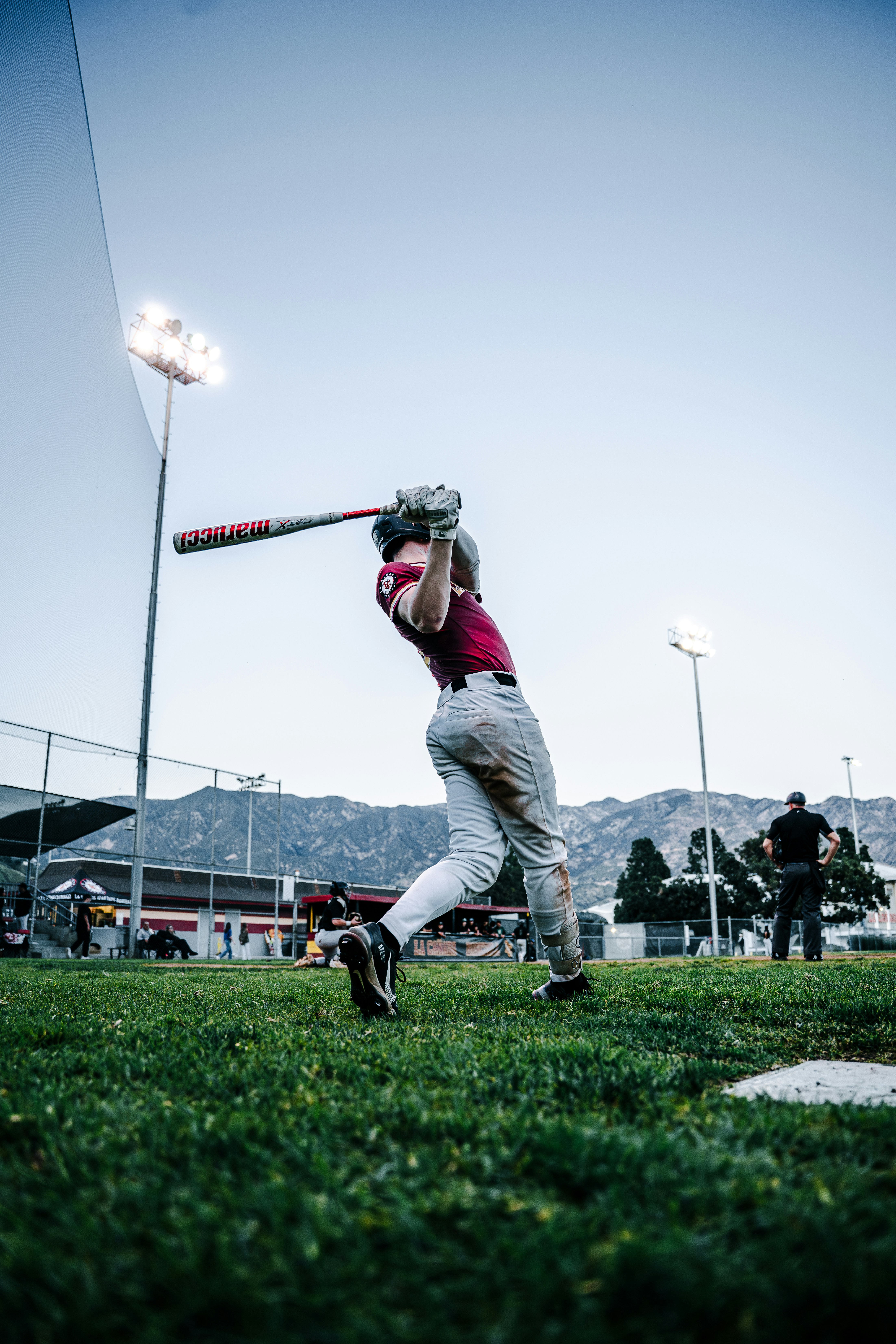 A baseball player swings at a pitch during a game.