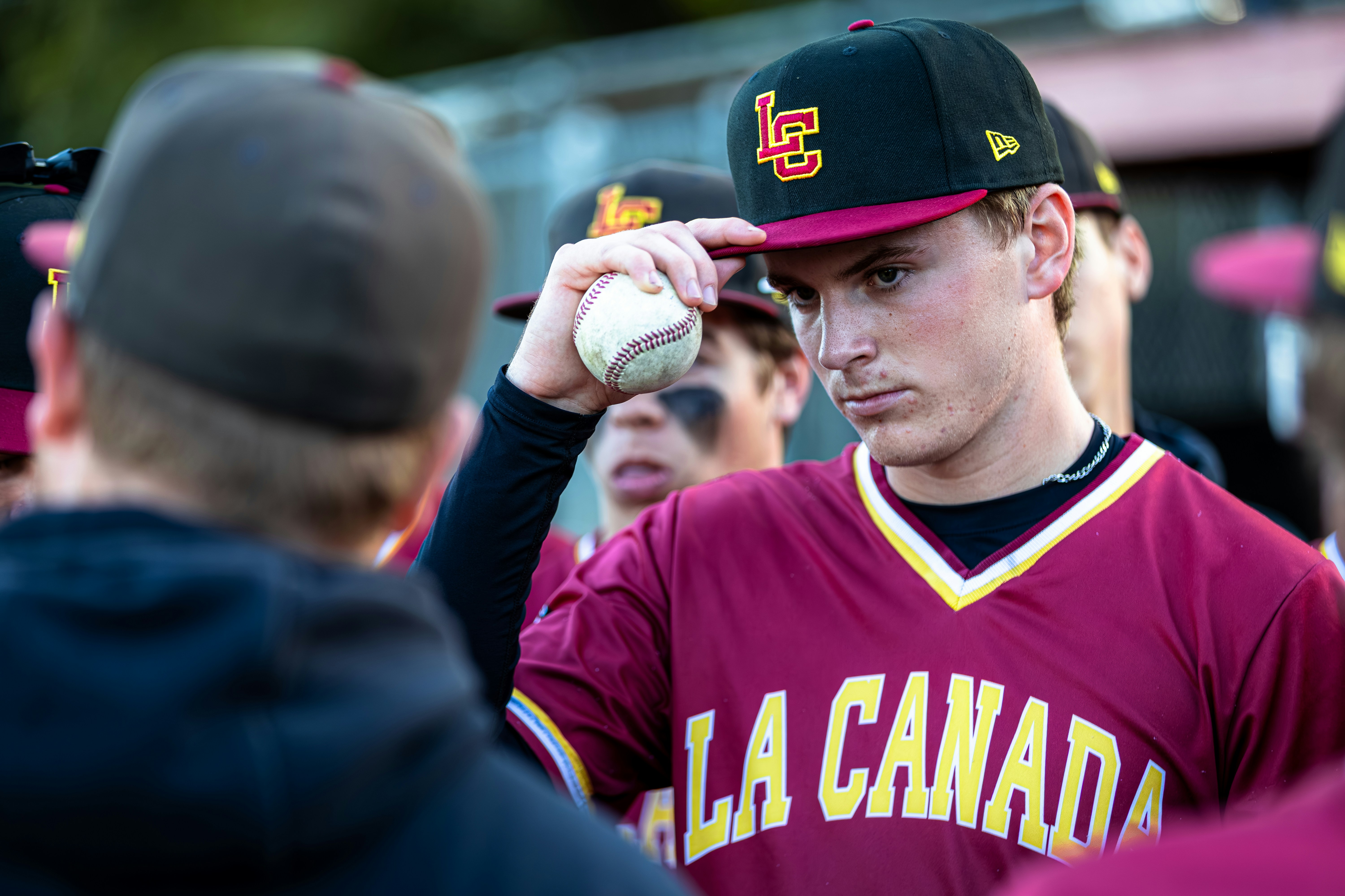 Young baseball player adjusts his cap during game
