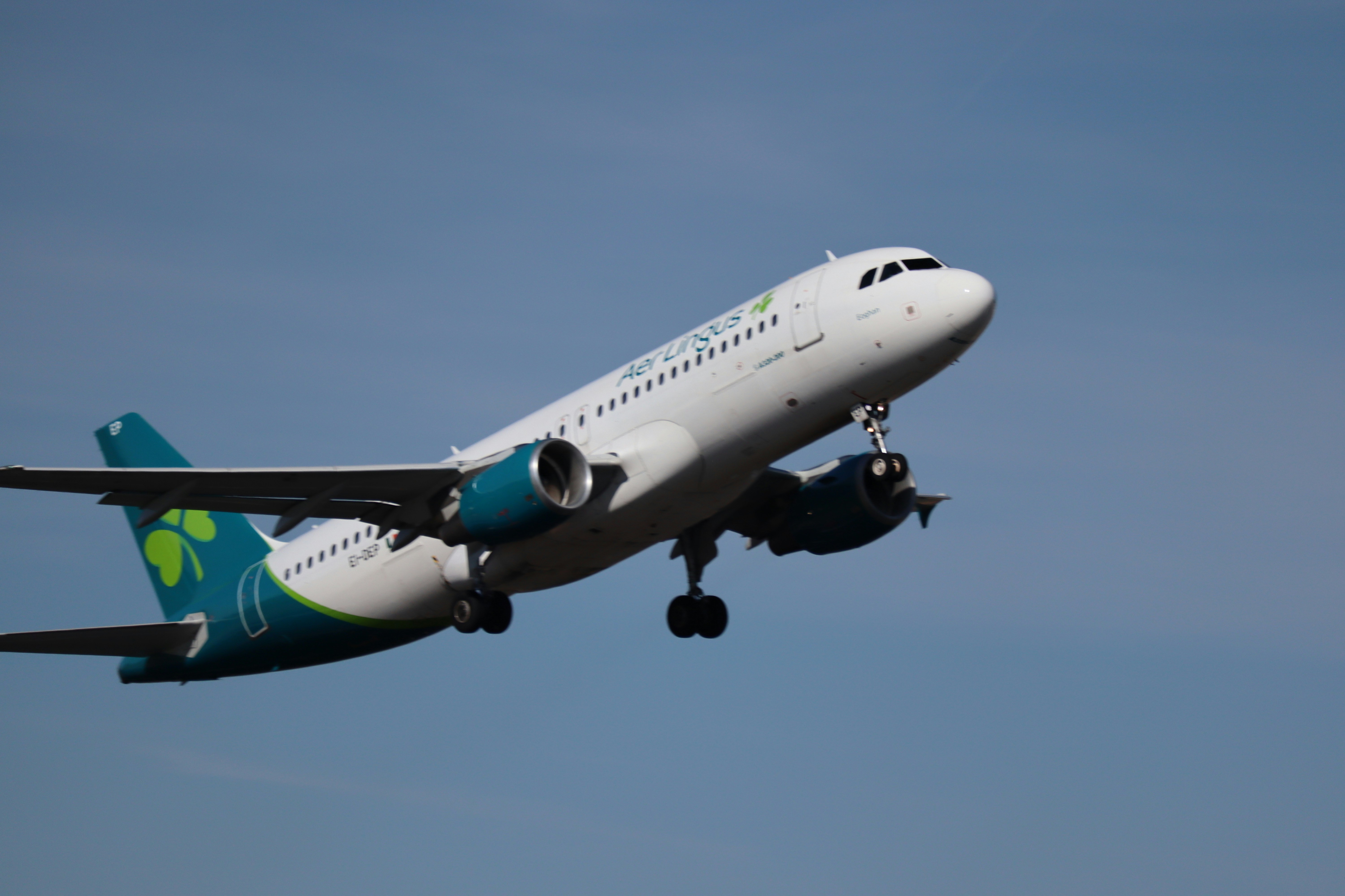 Airplane ascending into a clear blue sky