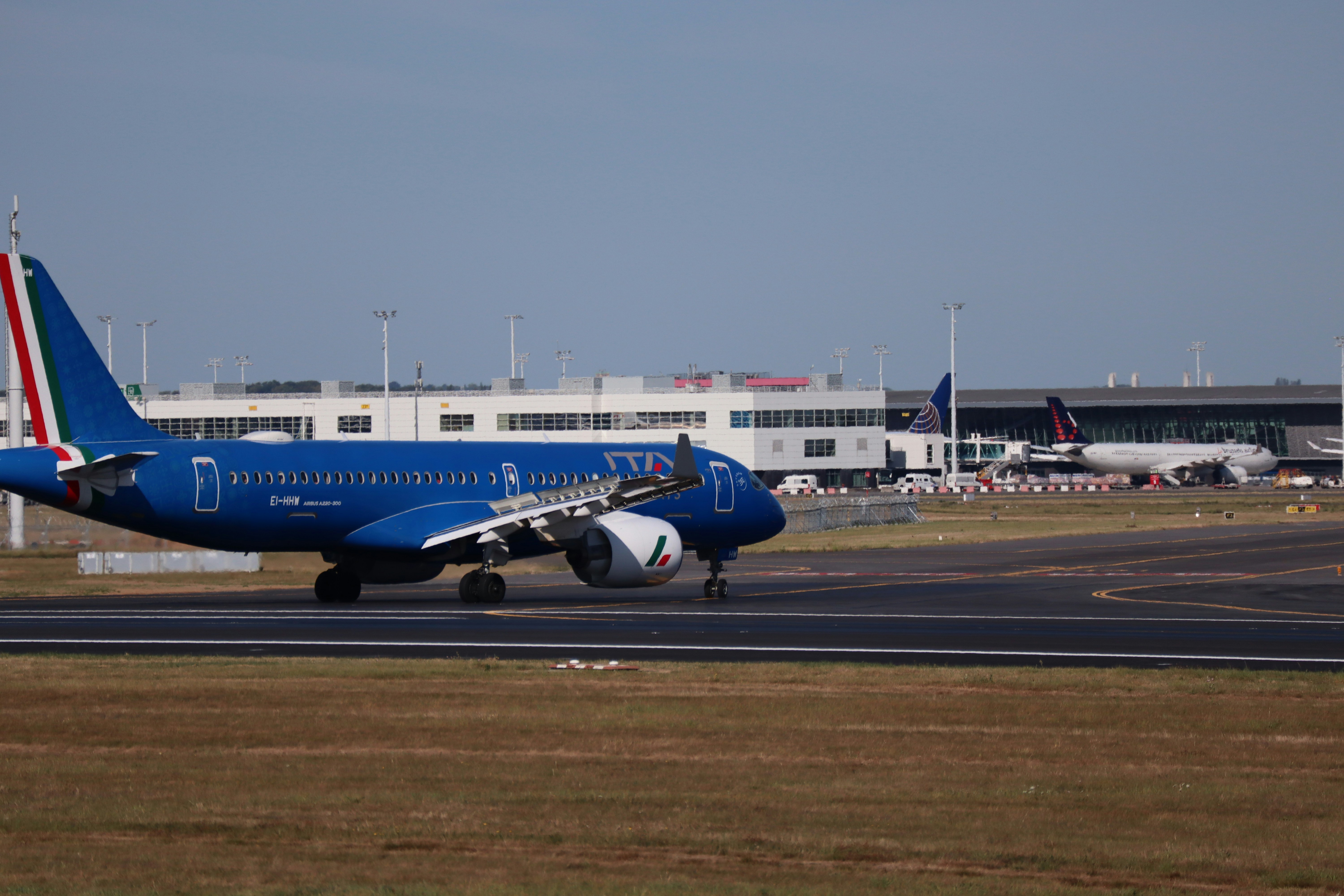 Blue airplane taxiing on airport runway