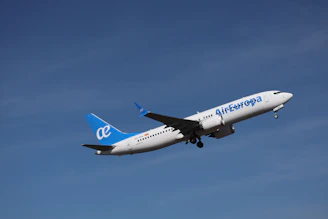 An air europa airplane ascends into a clear blue sky.