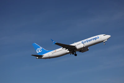 An air europa airplane ascends into a clear blue sky.