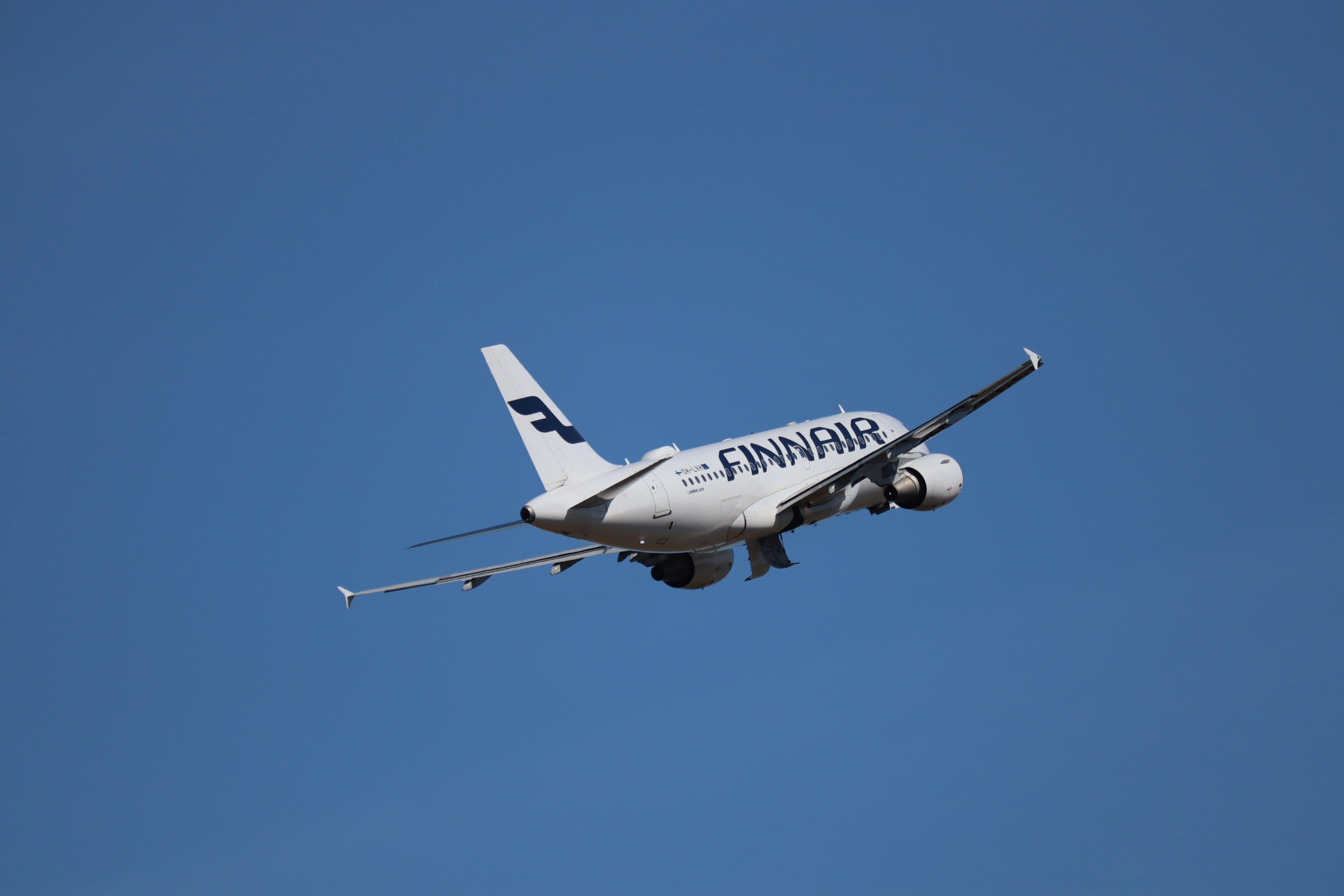 Finnair airplane ascending into a clear blue sky