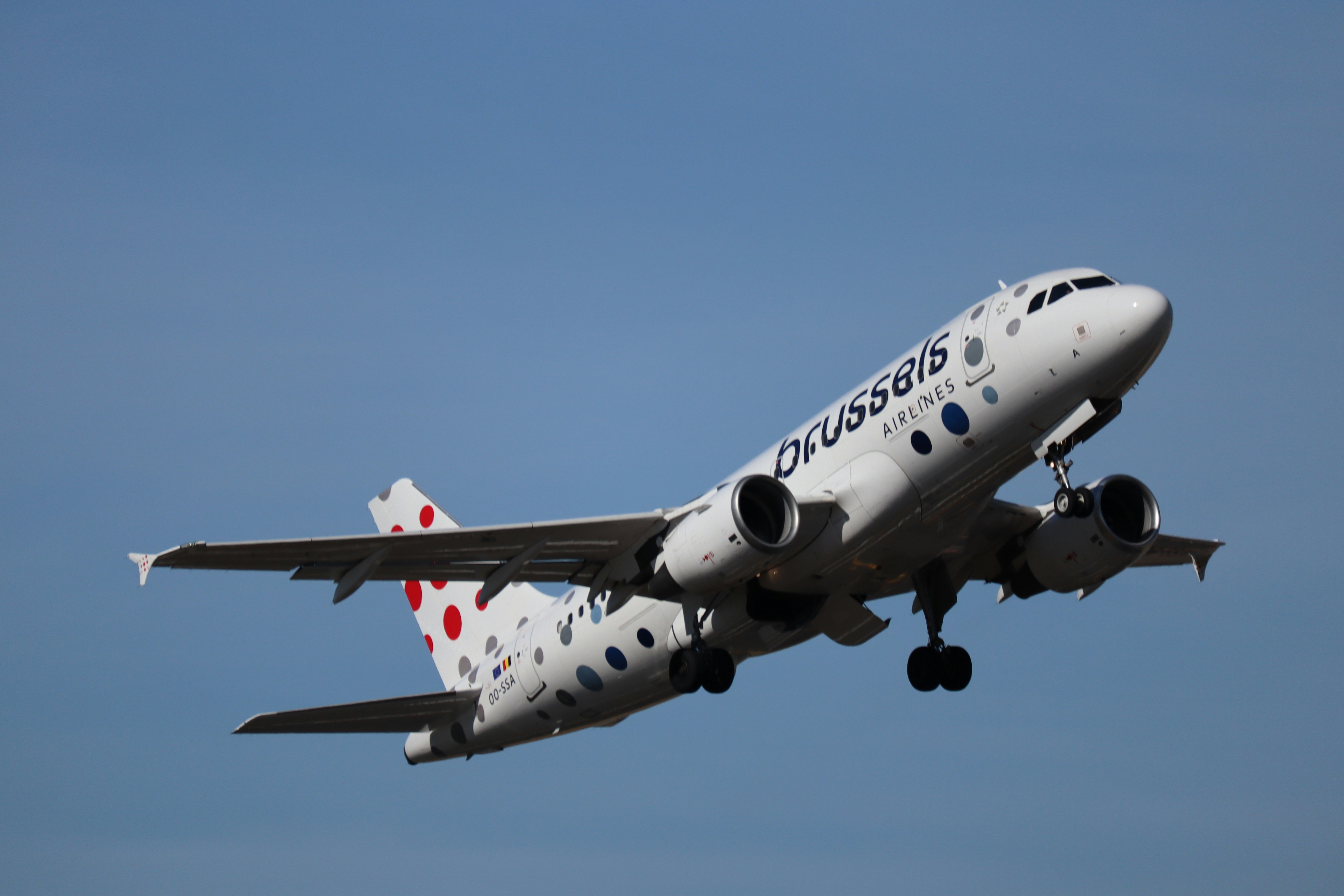 A commercial airplane taking off into a clear blue sky.