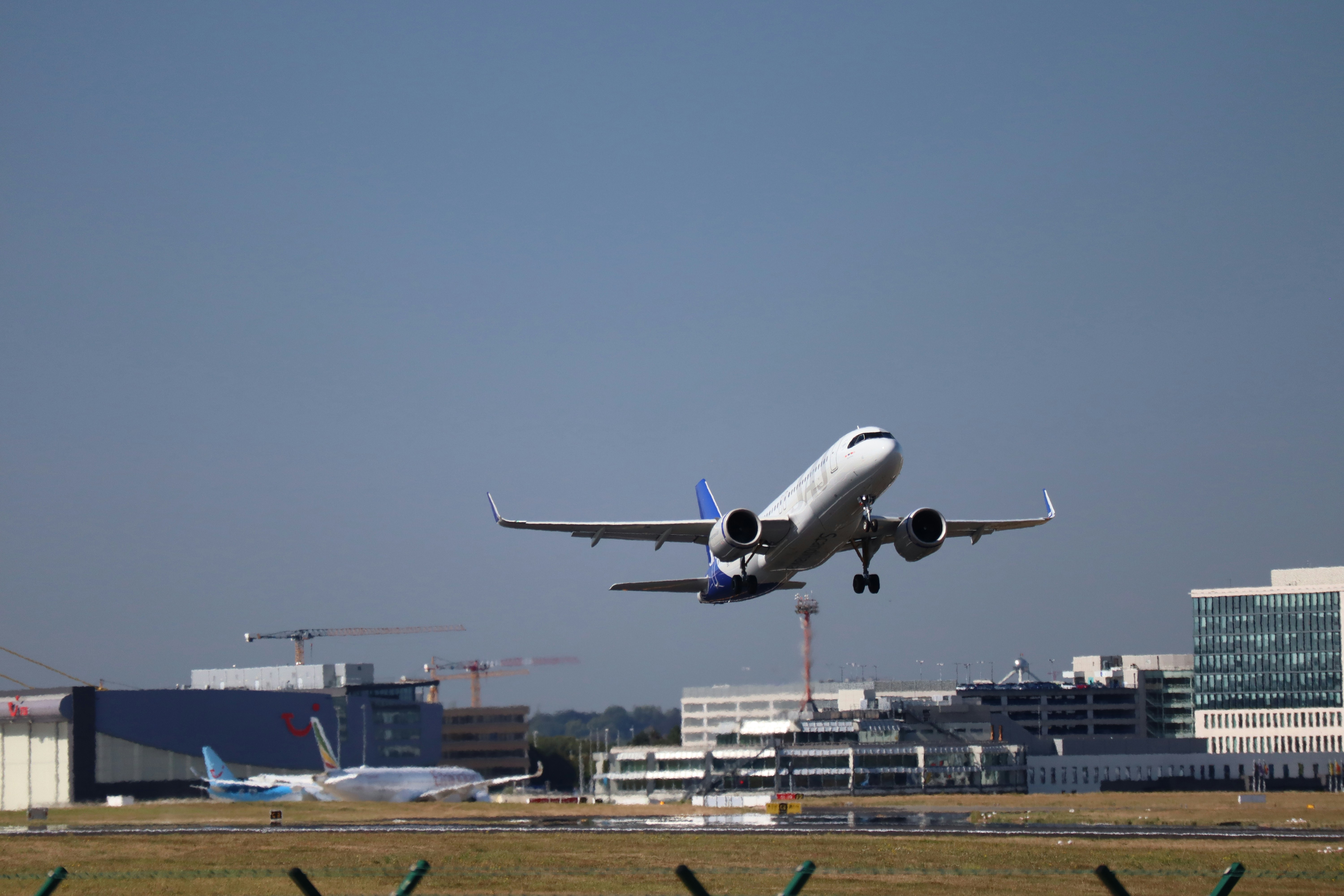 Airplane taking off with airport buildings in background