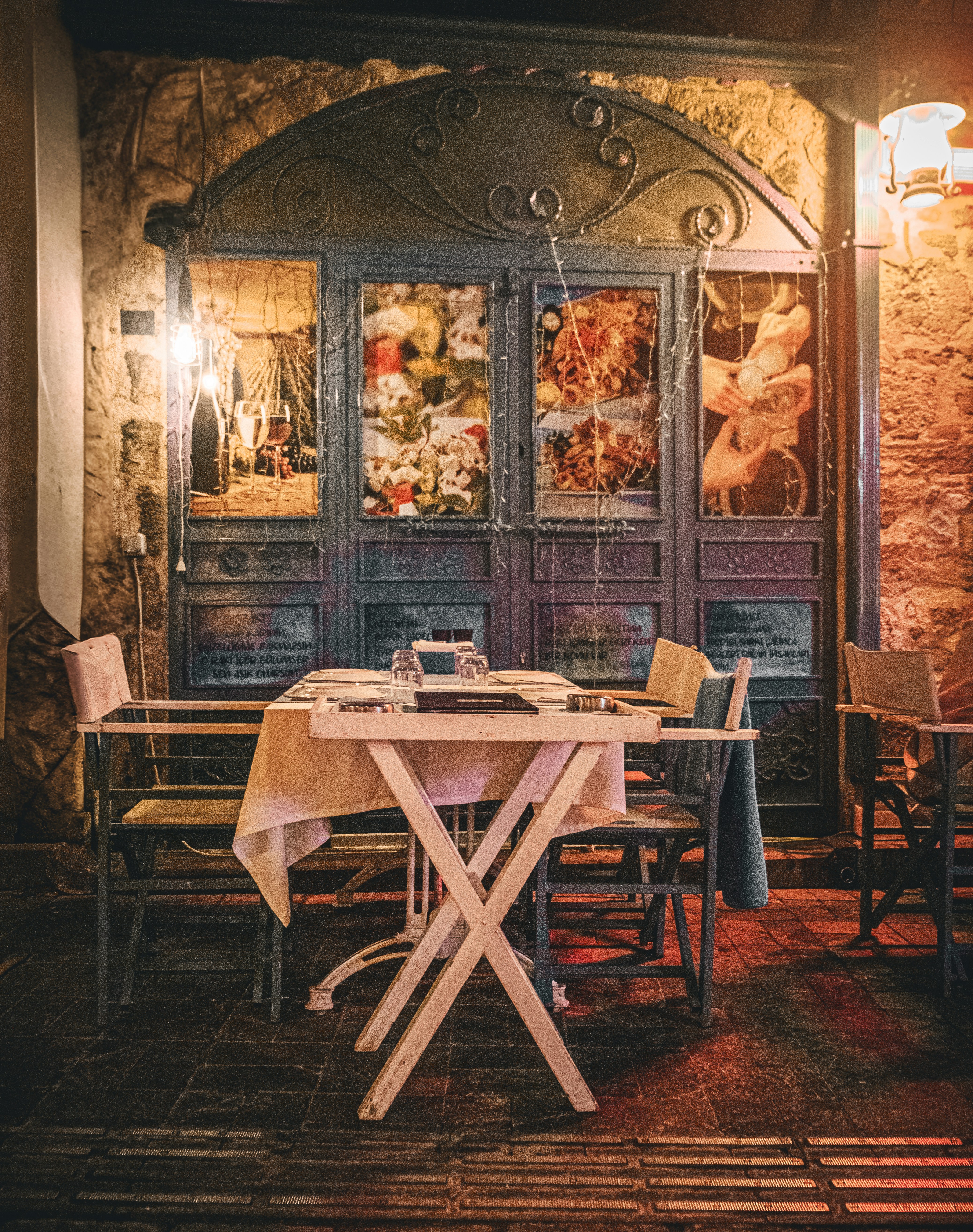Restaurant table set in front of ornate blue doors