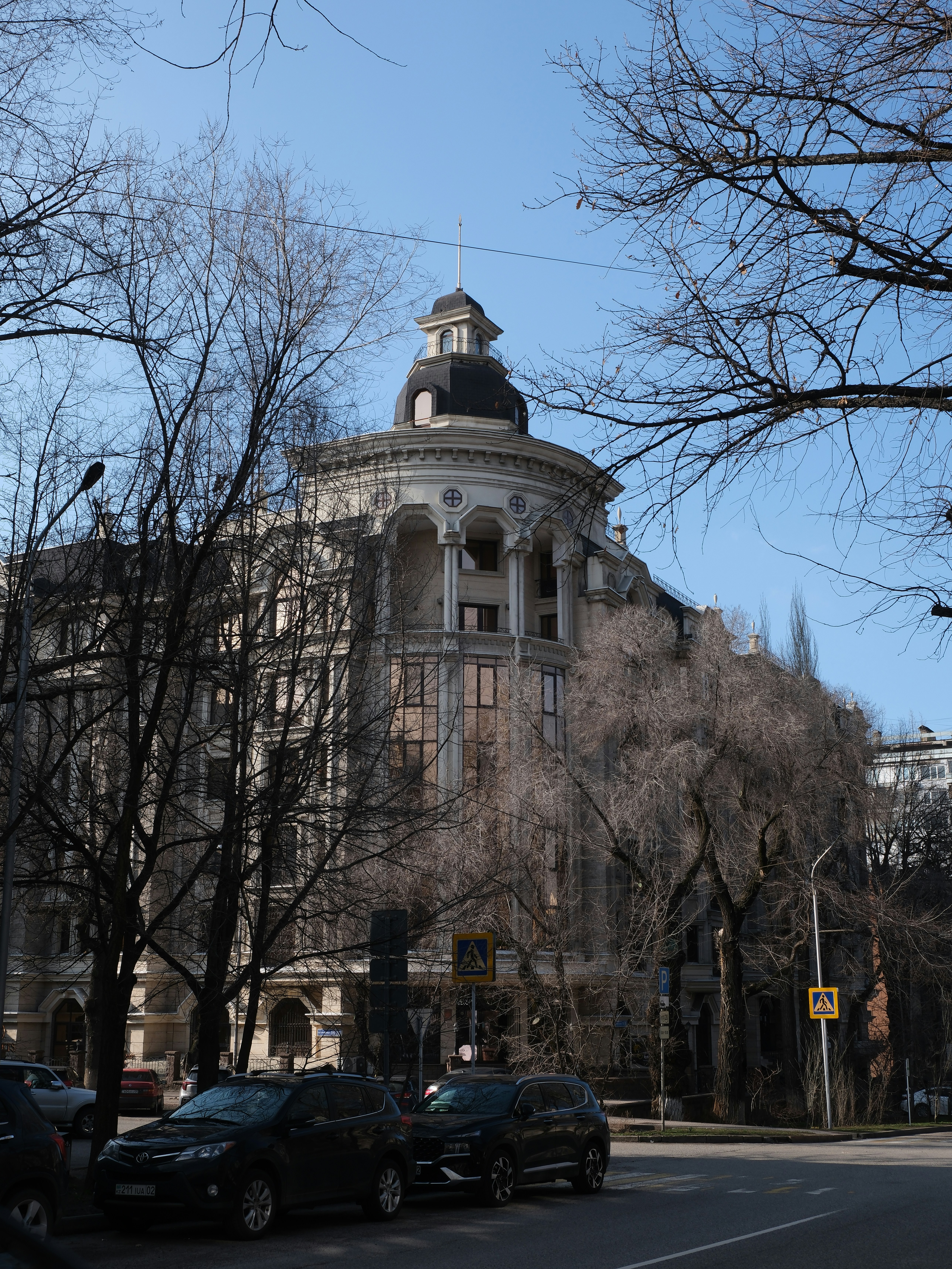 Ornate building with a dome and bare trees.