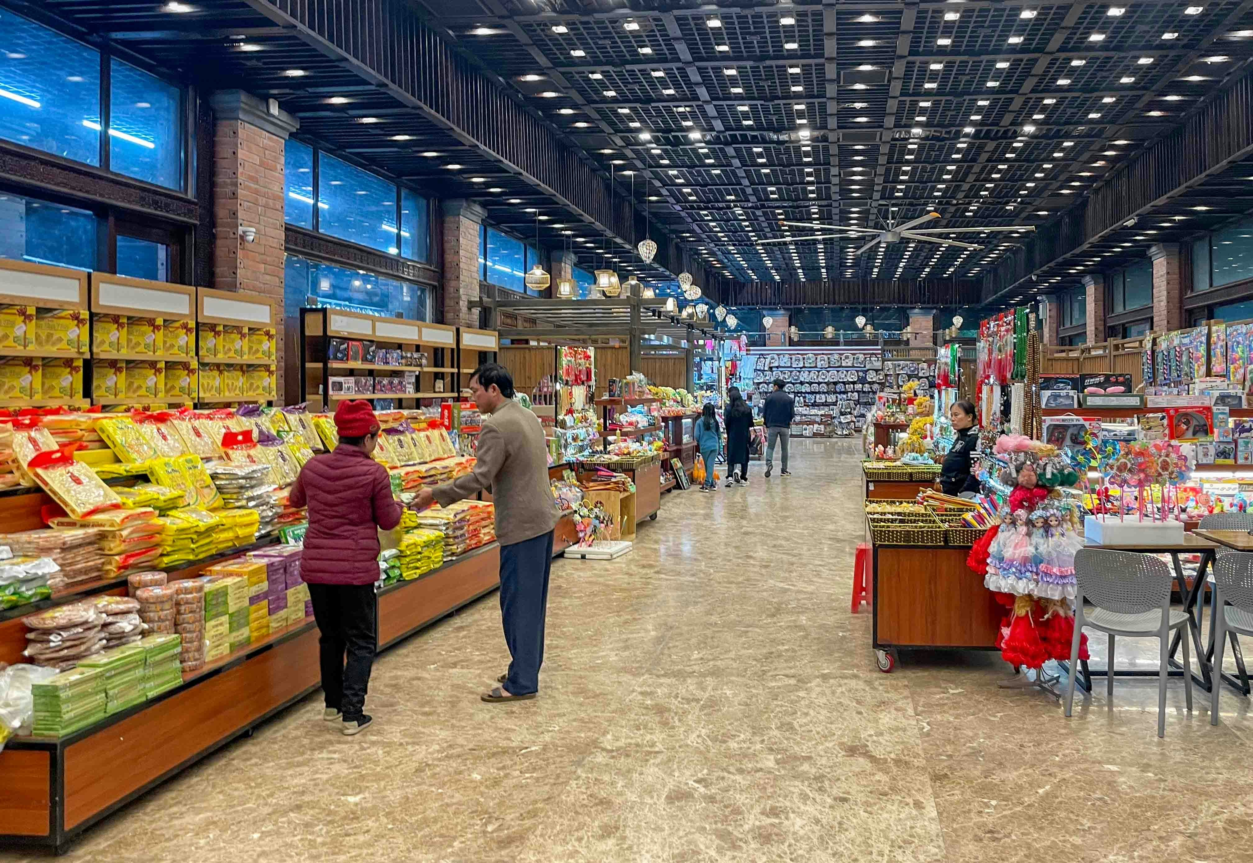 People shopping in a well-stocked grocery store aisle.
