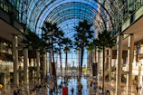 Interior of large building with palm trees and glass ceiling