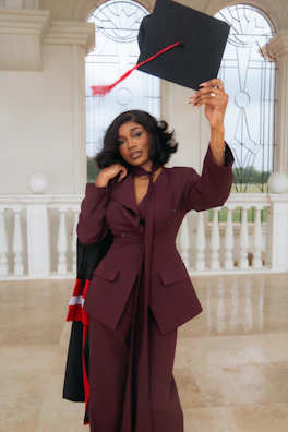 A woman in a suit holding a graduation cap