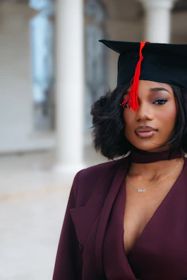 A young woman in graduation cap and gown.
