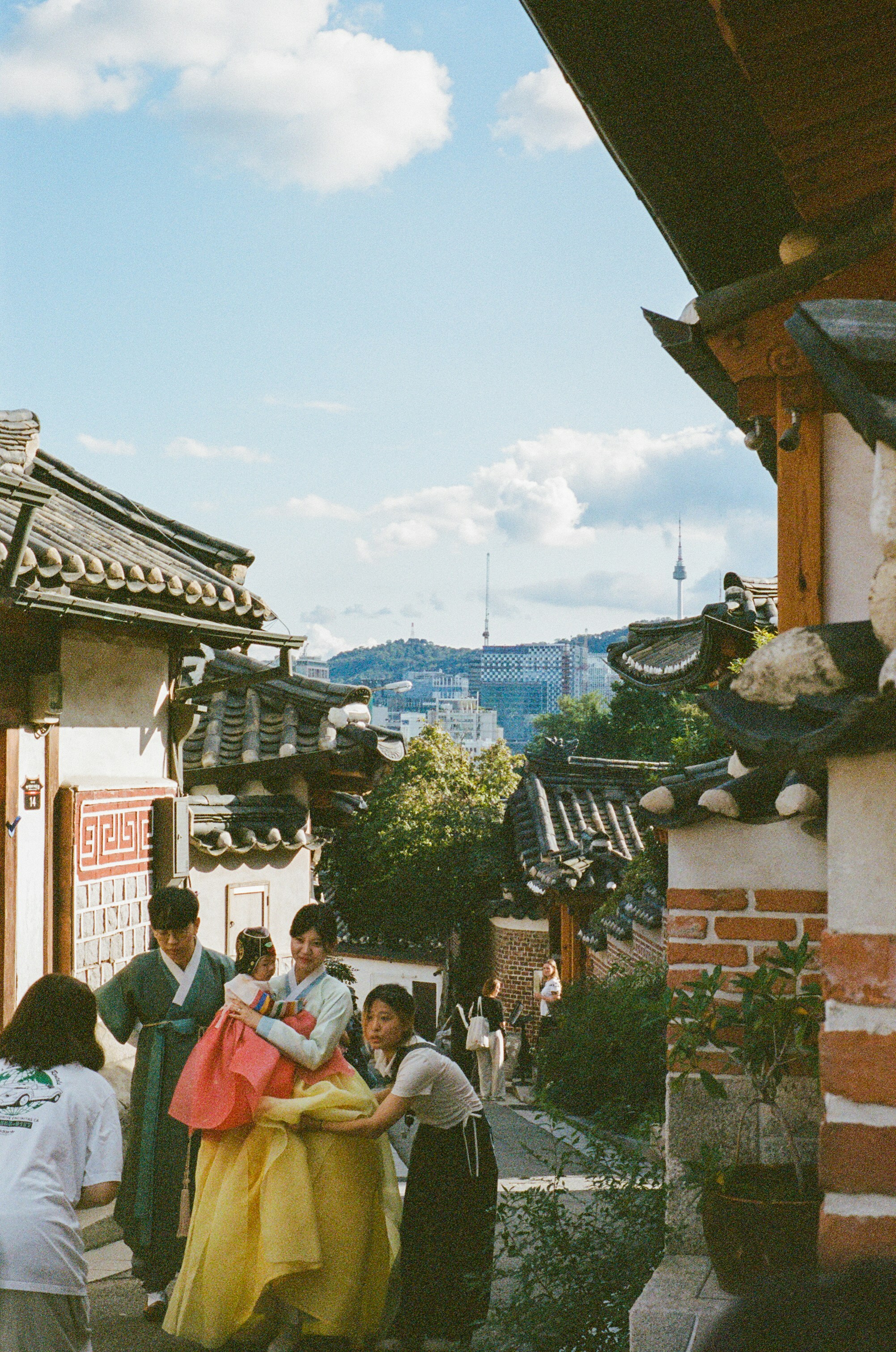 伝統的な韓国韓服を着た人々が歴史ある村を歩いている