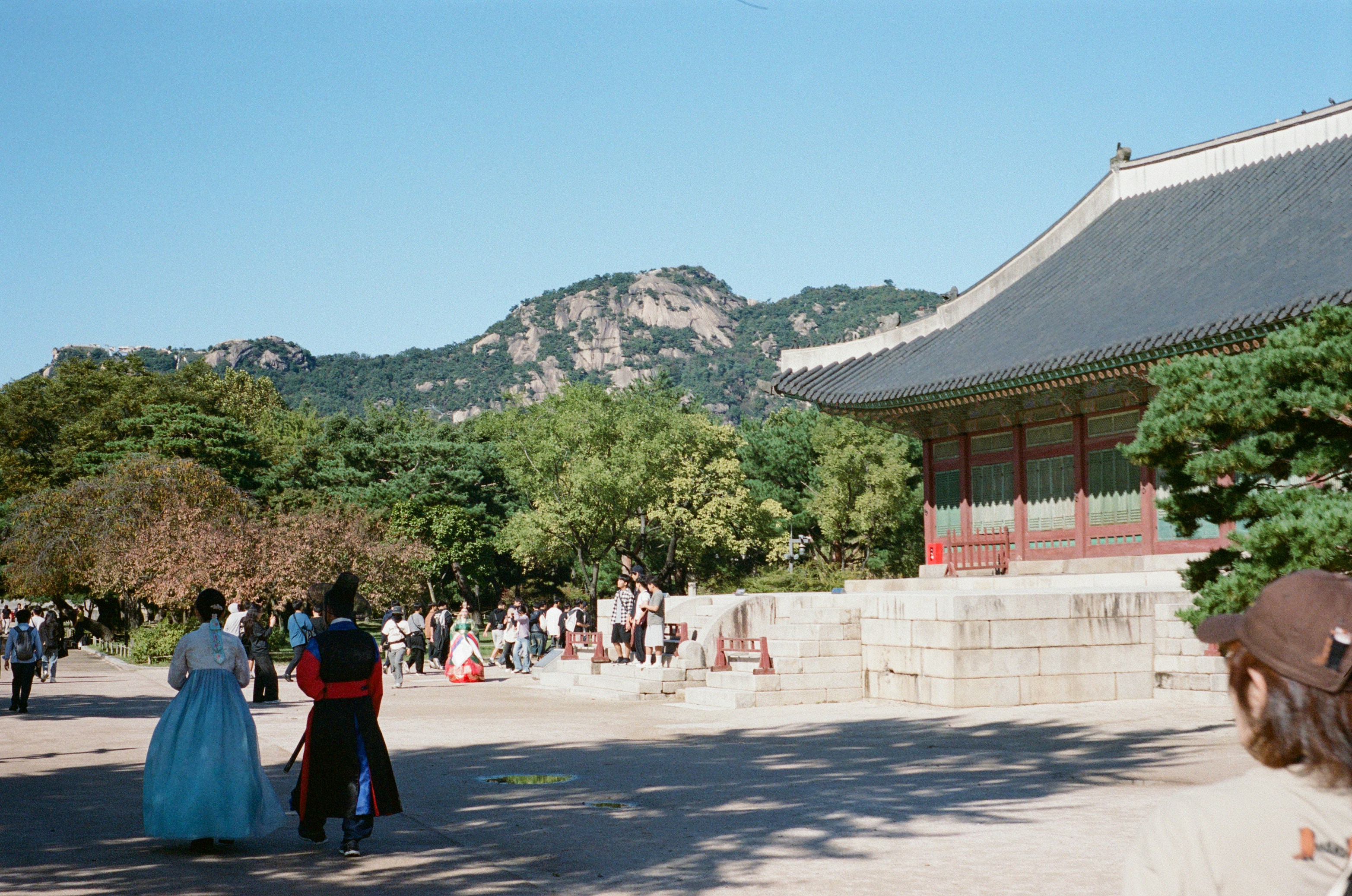 歴史的な宮殿にいる伝統的な韓国衣装を着た人々