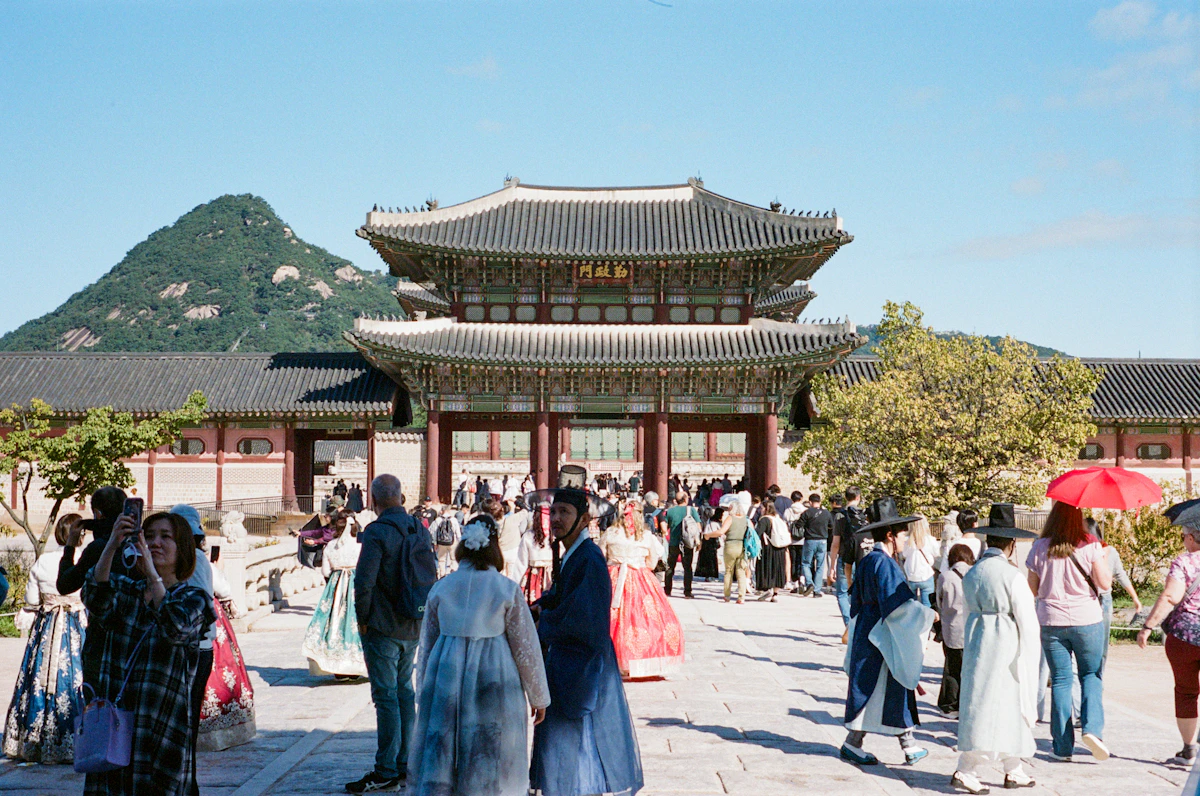 Visitors in hanbok in front of Gyeongbokgung Palace with Bugaksan behind
