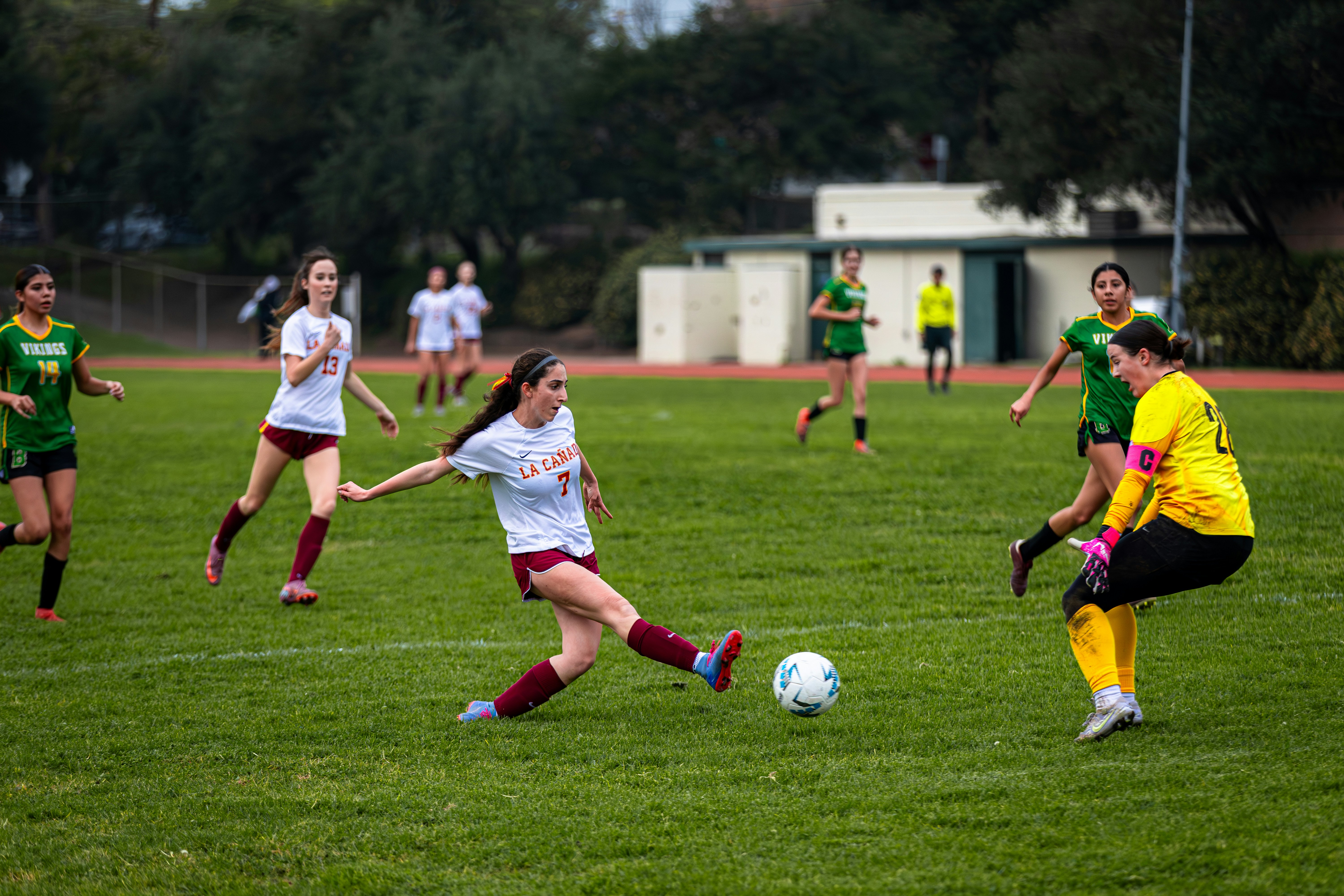 5c80965ce19483bb - Young women playing a soccer game on a field.