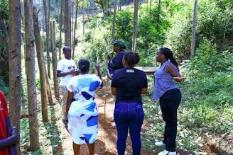 A group of people standing in a wooded area.