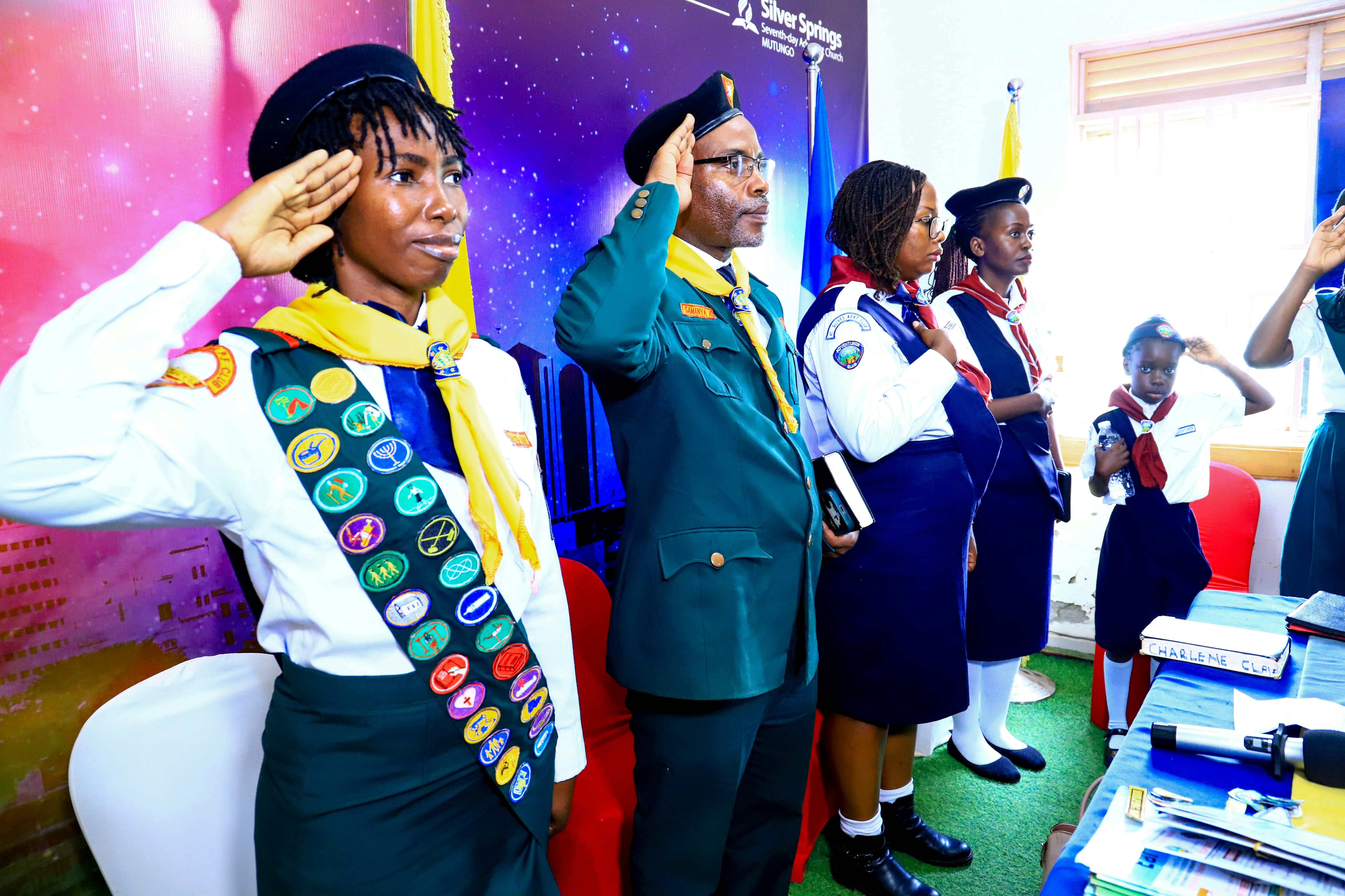 Group of people in scout uniforms saluting