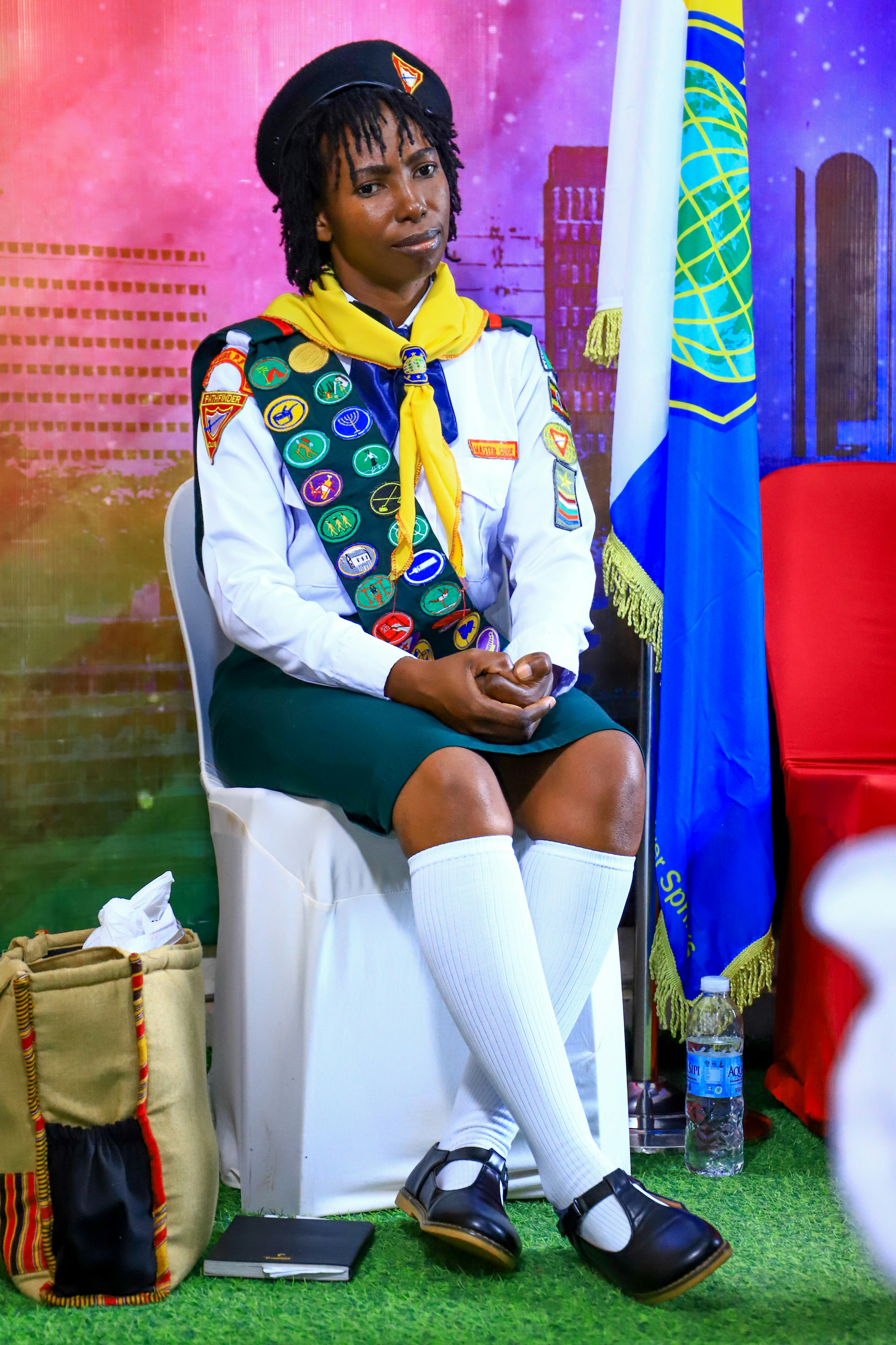 Young woman in scout uniform sitting on chair