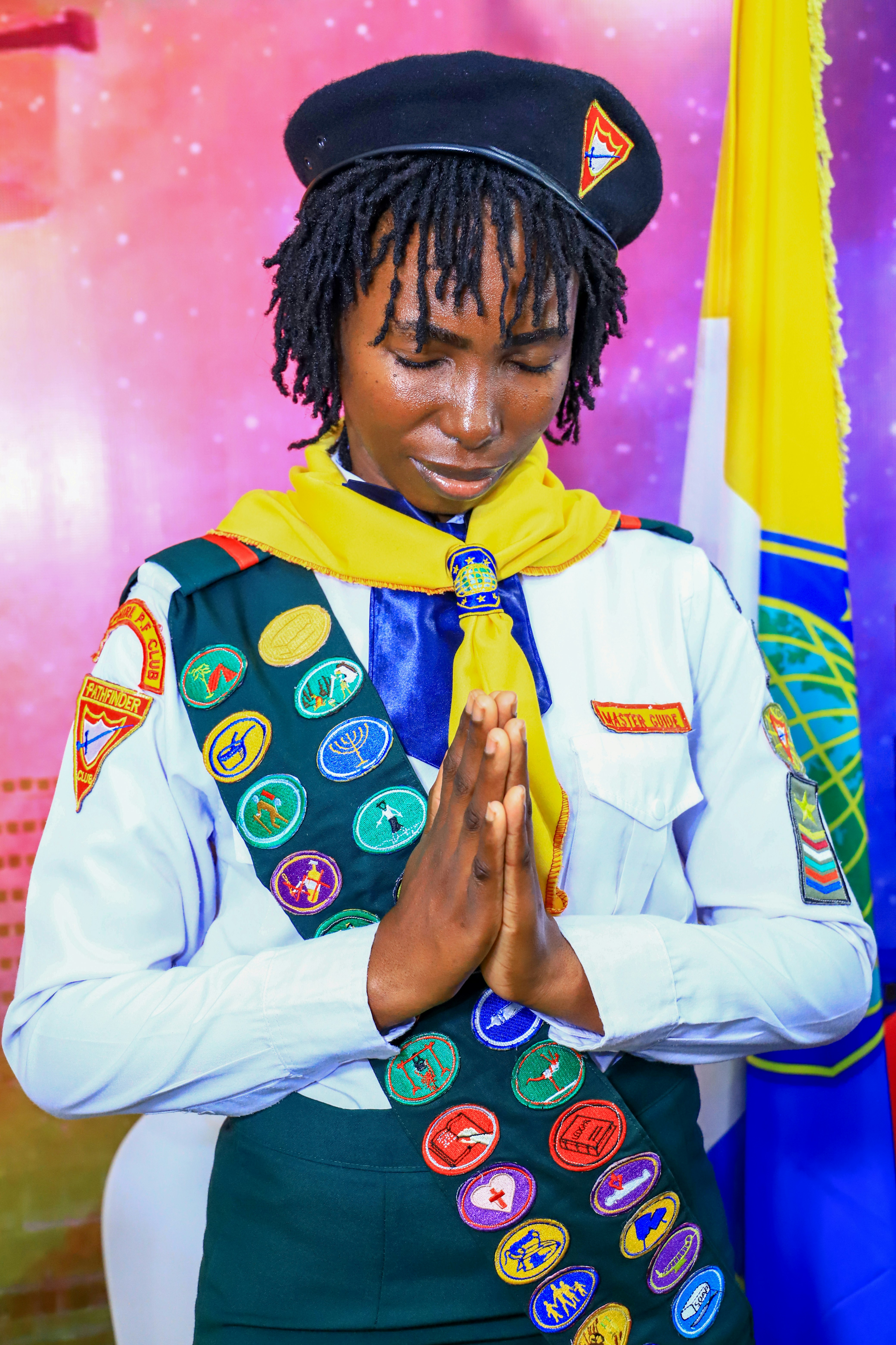 Young woman in scout uniform praying with hands together