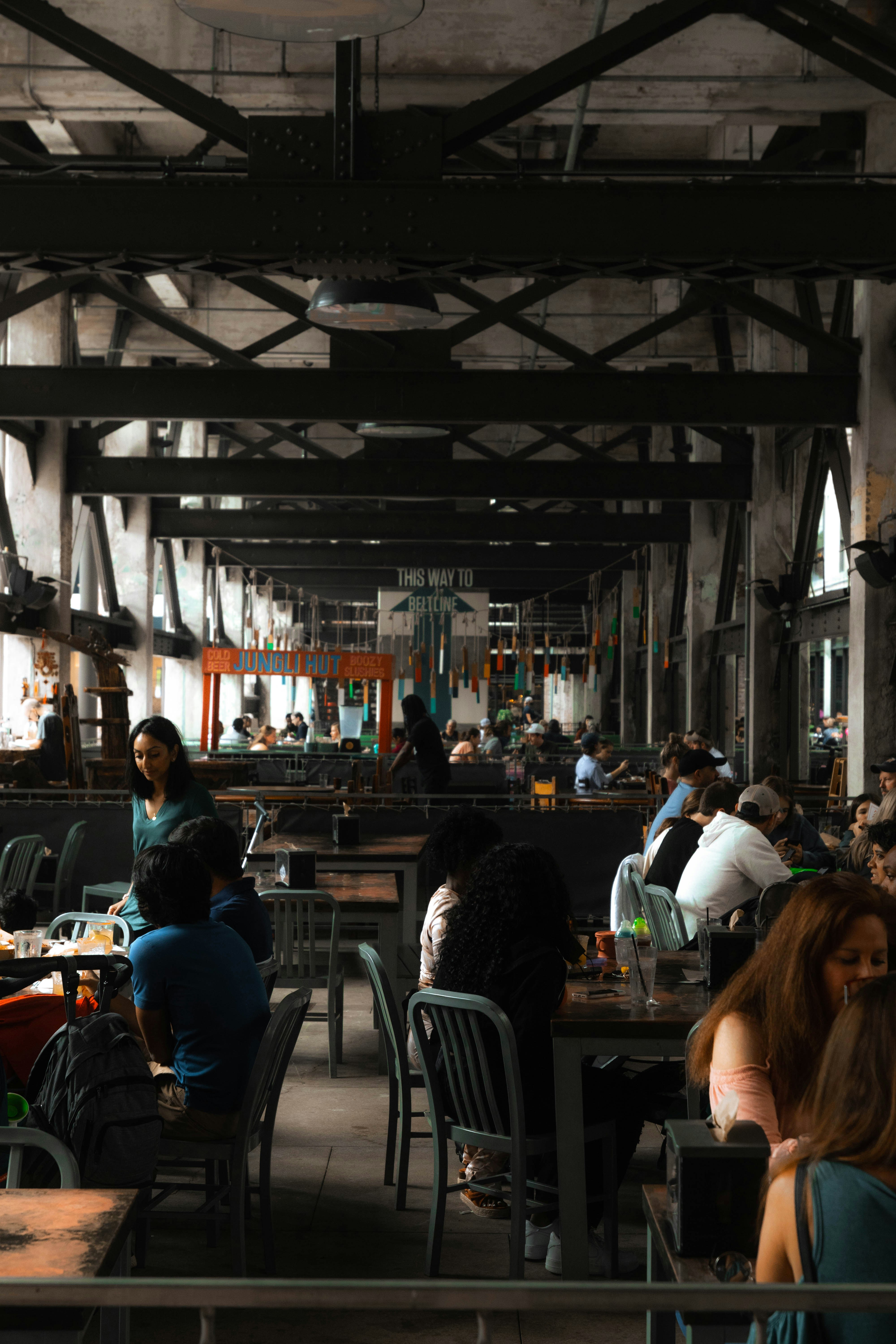 People dining in a spacious industrial-style restaurant.