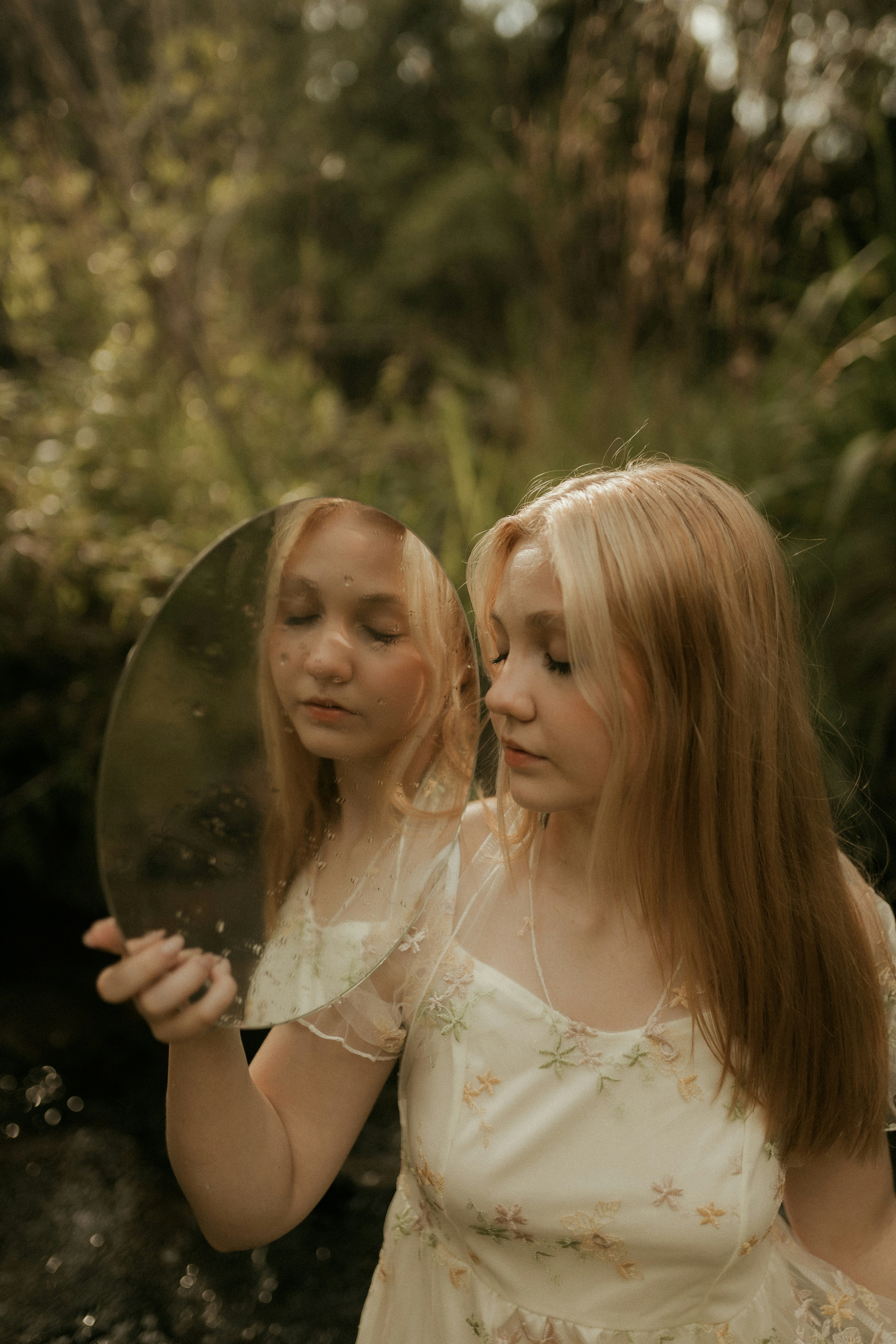 Junge Frau, die ihr Spiegelbild im Spiegel betrachtet