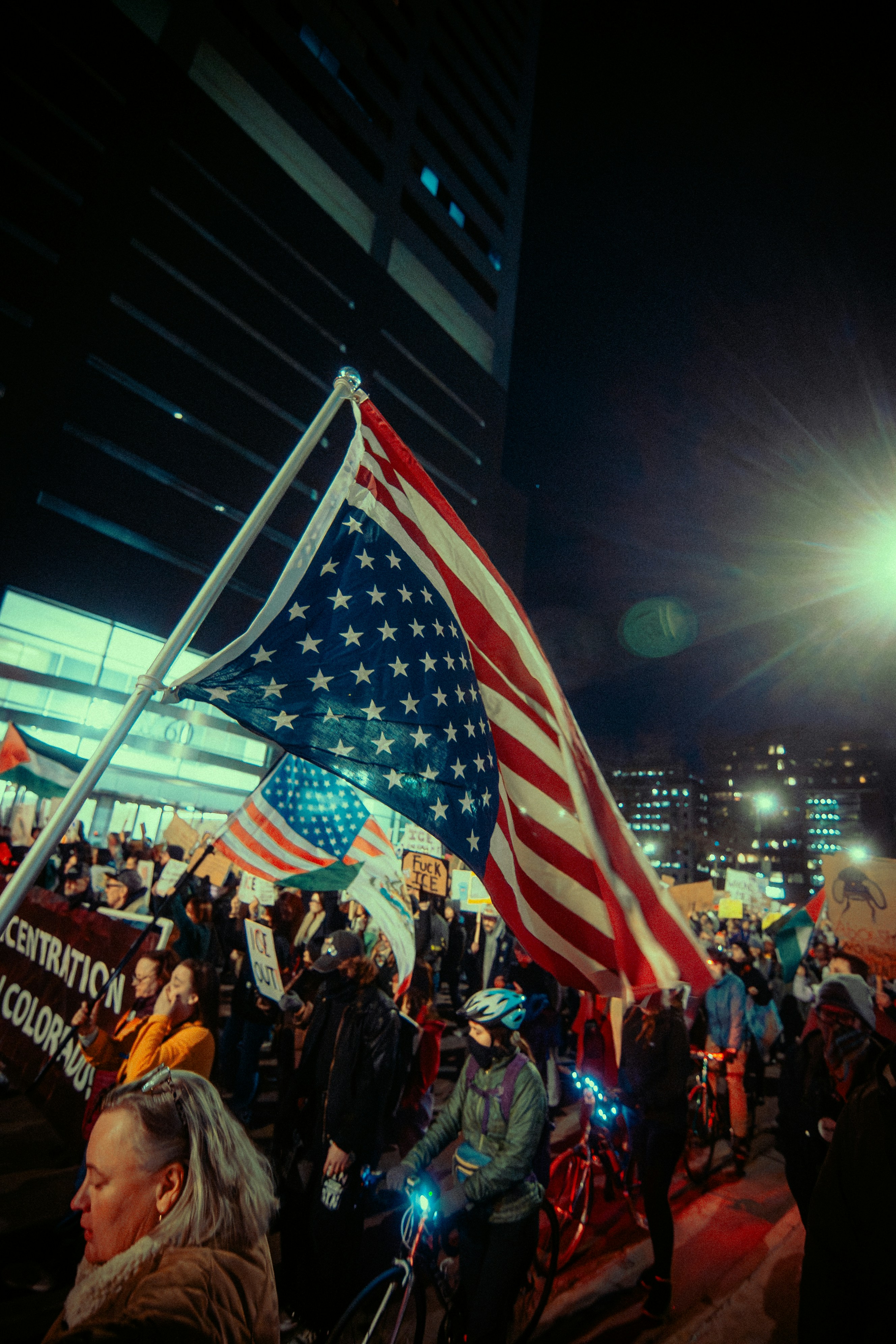 Le drapeau américain flotte au-dessus d’une foule la nuit