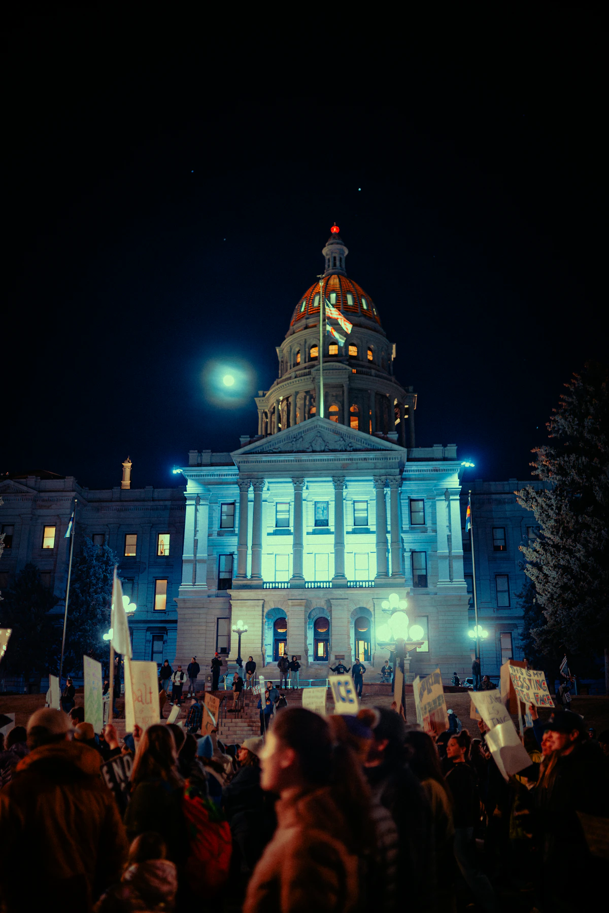 Crowd gathered at the Colorado State Capitol building at night for a civil rights demonstration