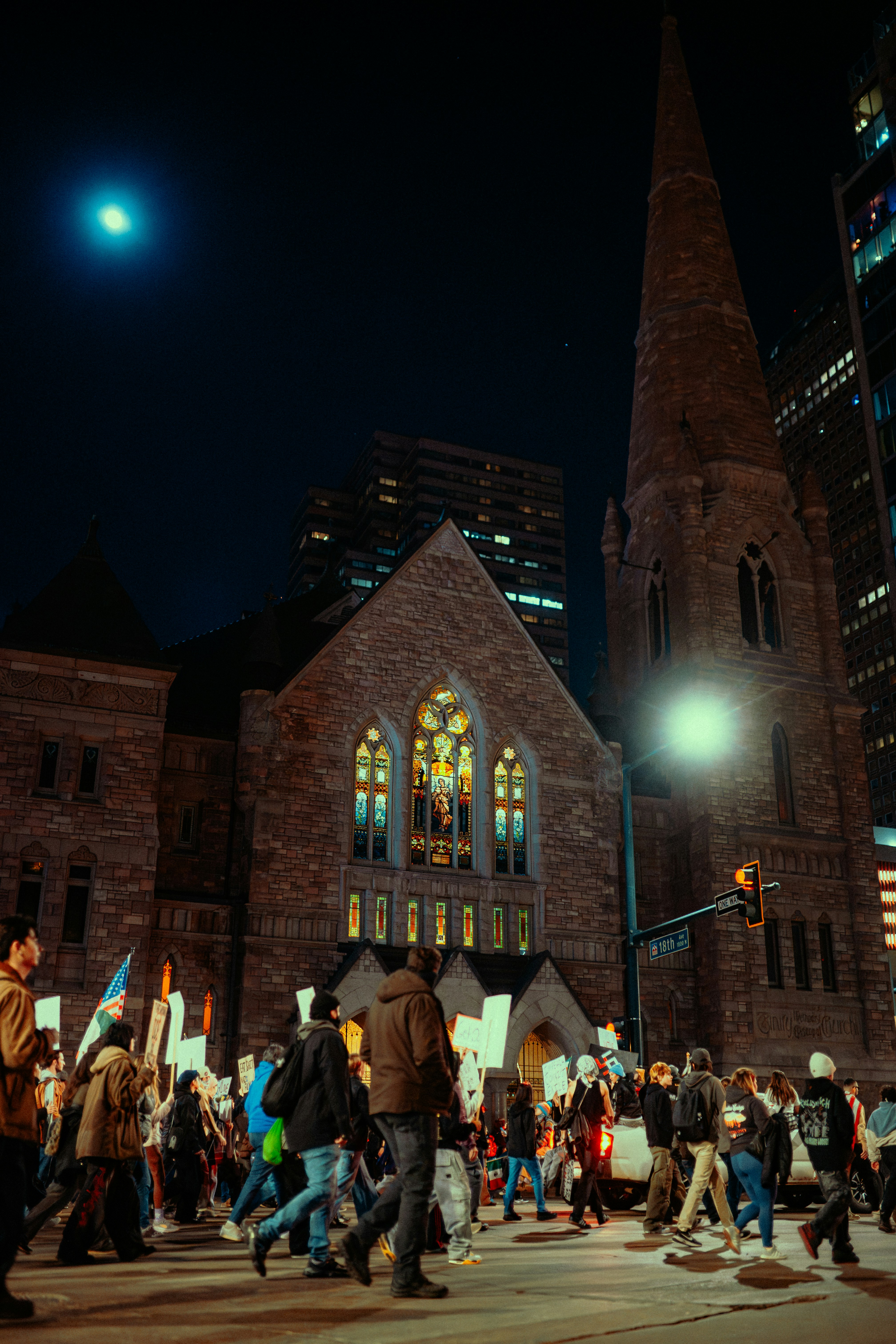 Les gens défilent la nuit devant une église.