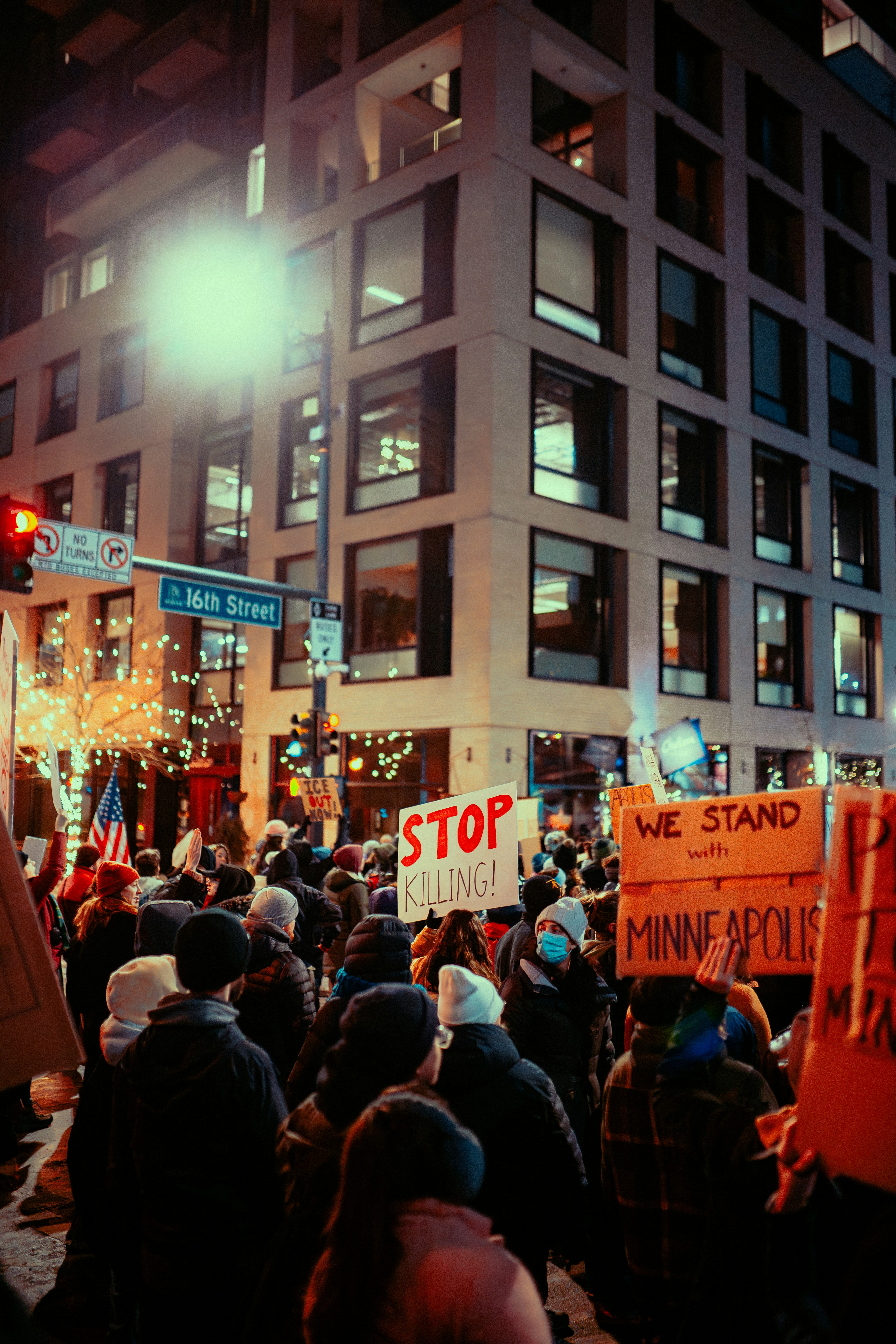 Des manifestants tiennent des pancartes lors d’une manifestation nocturne dans la rue.