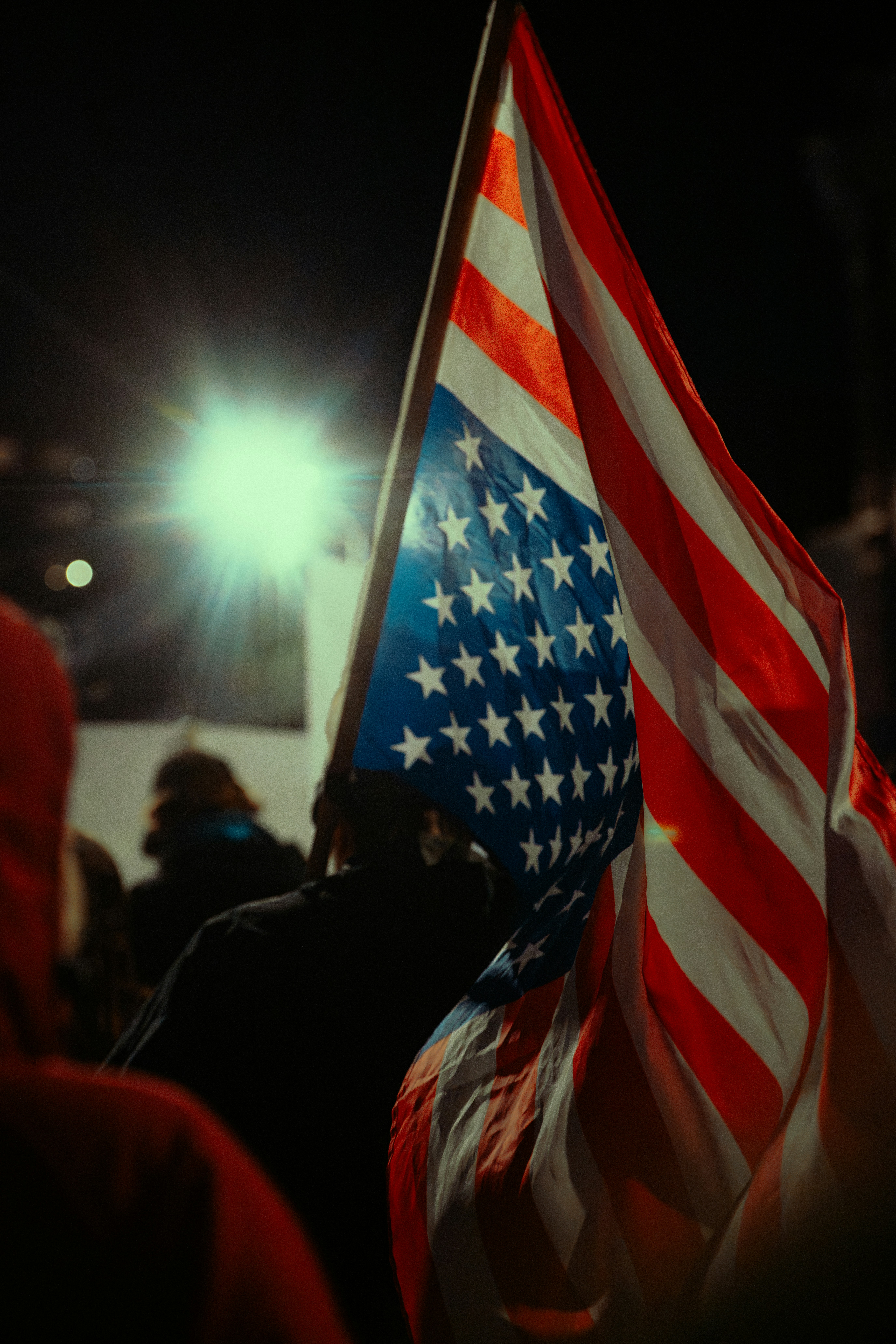 Drapeau américain flottant la nuit sous une lumière vive