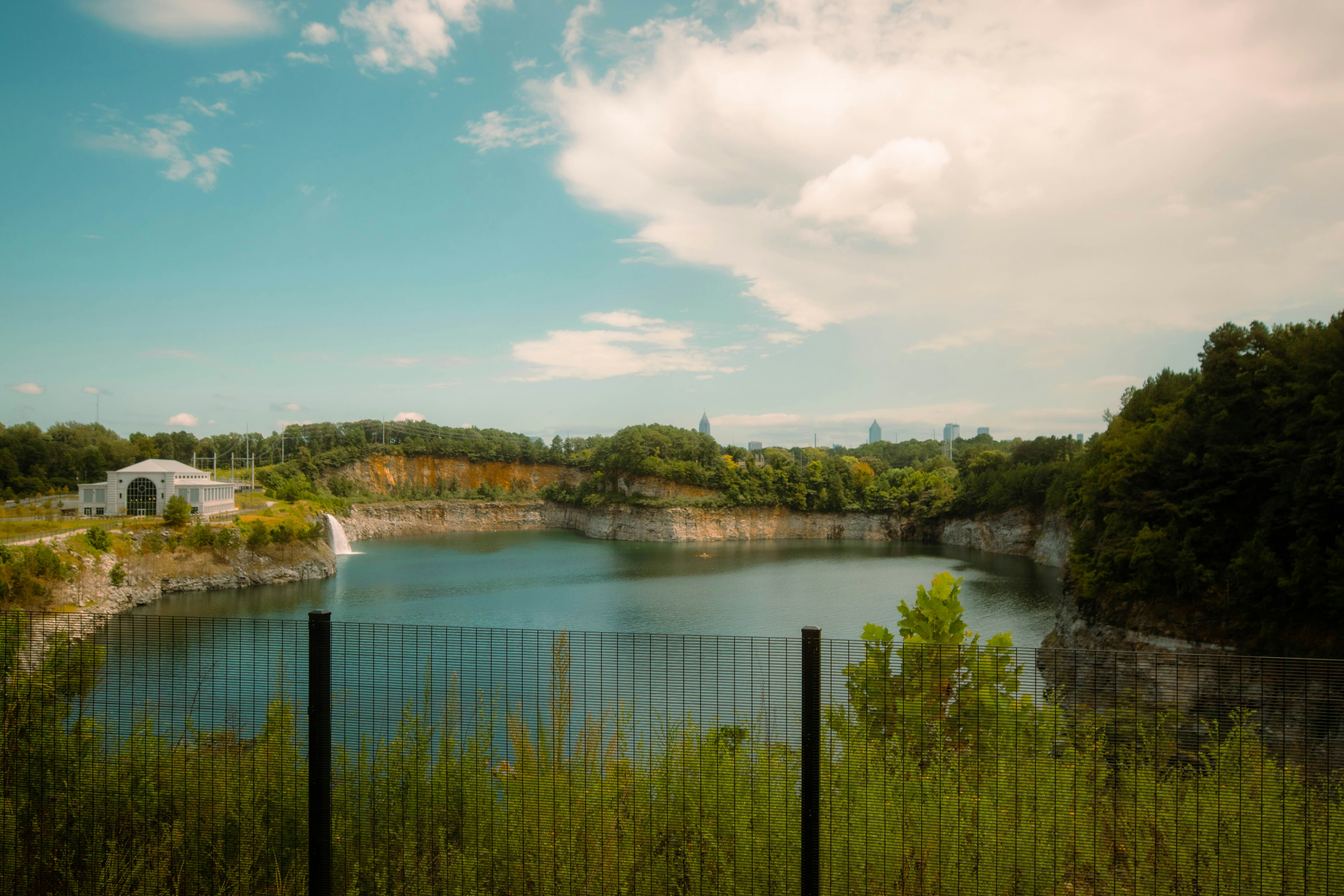 A calm lake surrounded by trees and rocky cliffs.