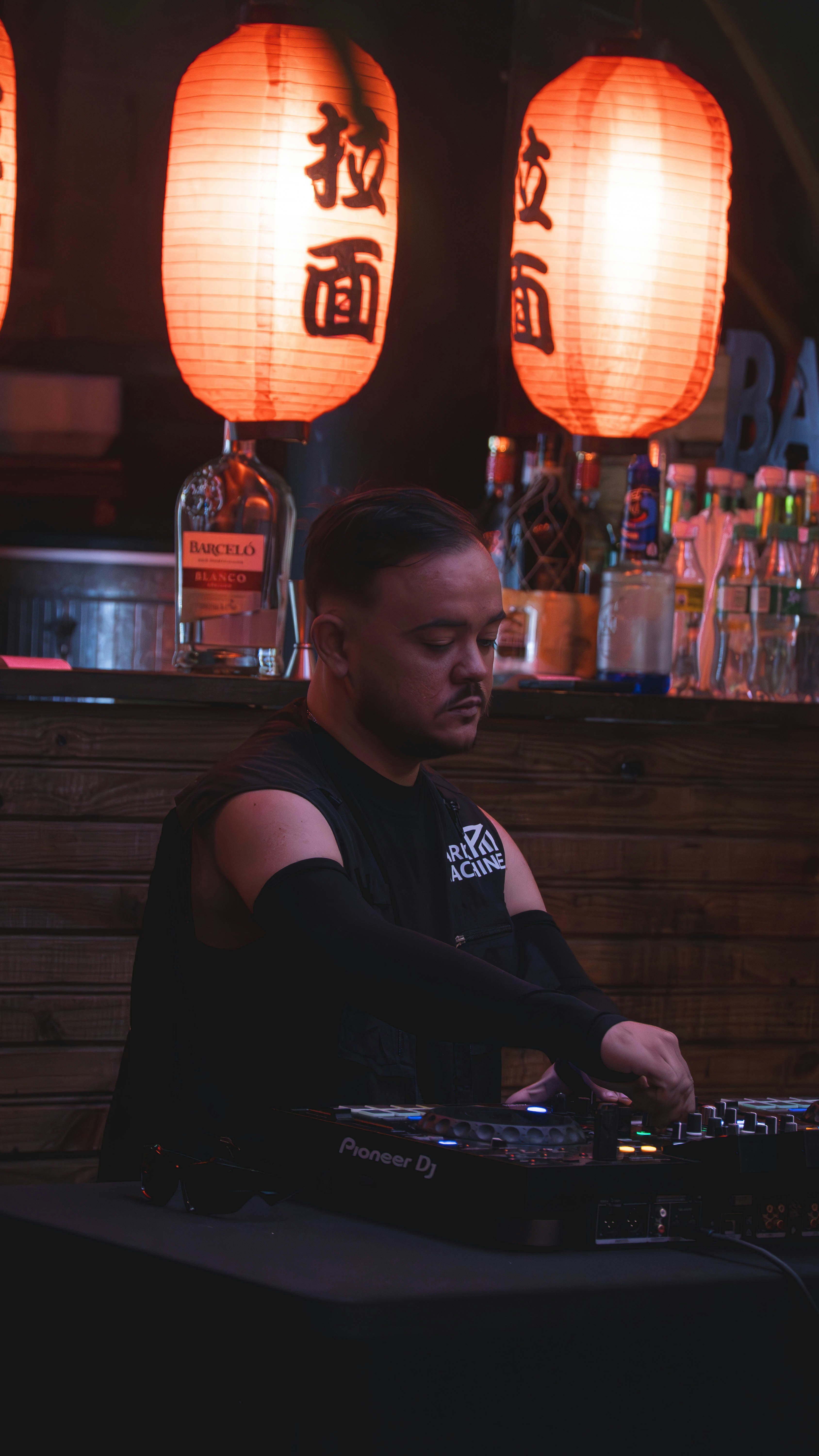 Dj playing music with japanese lanterns overhead